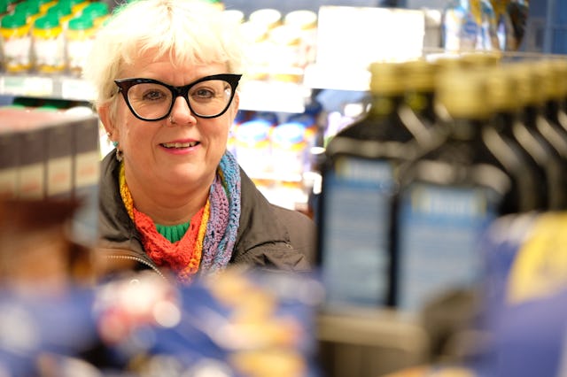 Suzann Larsdotter tittar fram mellan hyllorna på Coop.