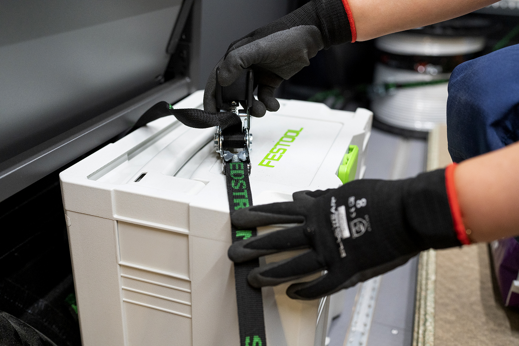 Någon spänner fast en låda.