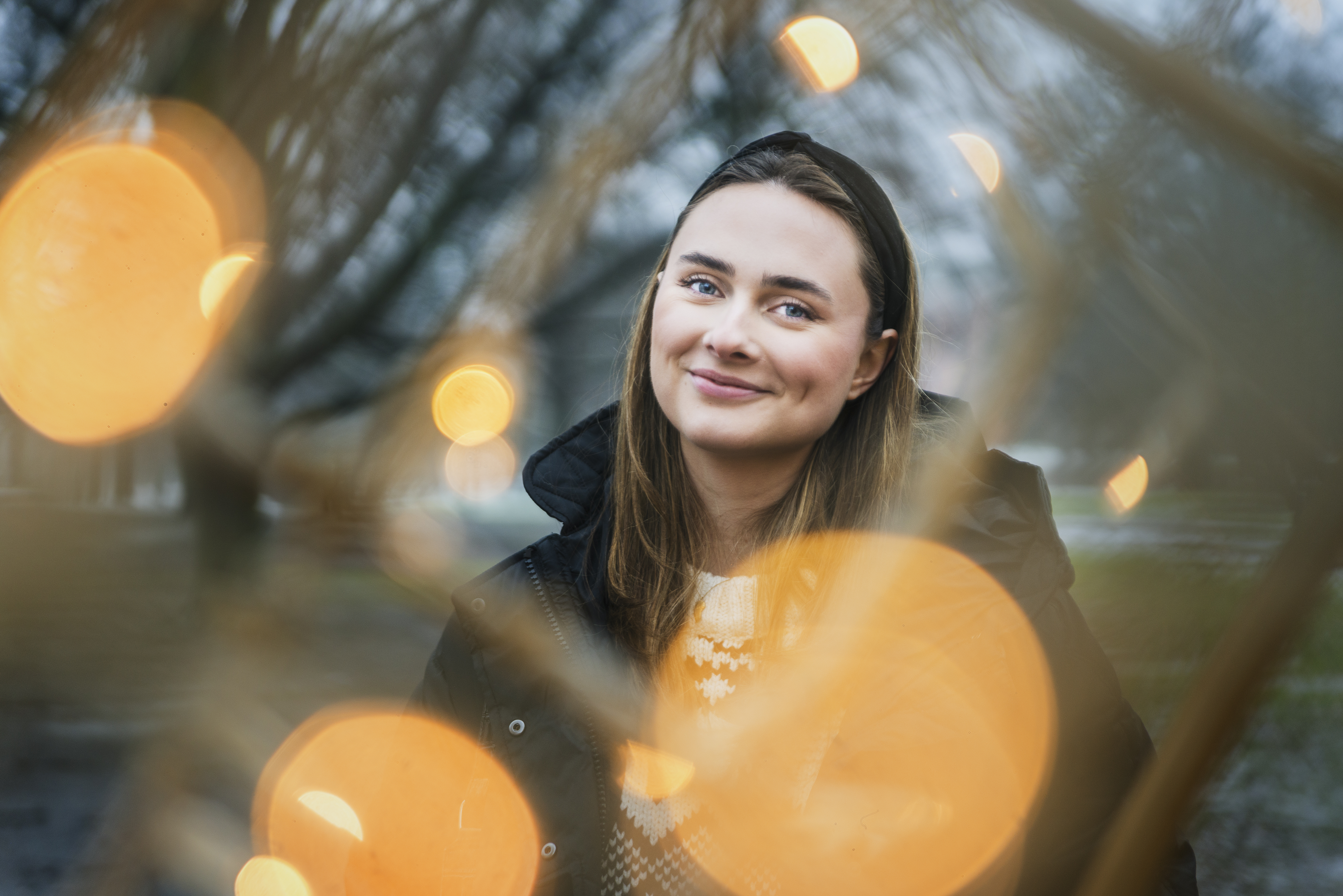 Tilde Wrigsell är en av låtskrivarna i Melodifestivalen 2023. I bilden omges hon av varma bollar av ljus.