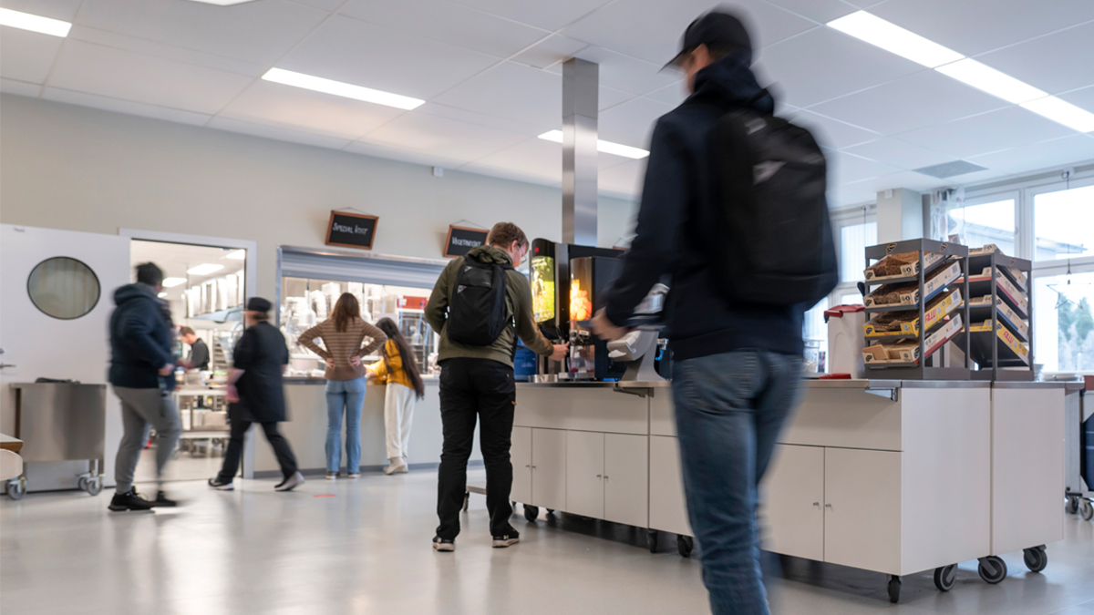 Elever och personal i en skolmatsal.