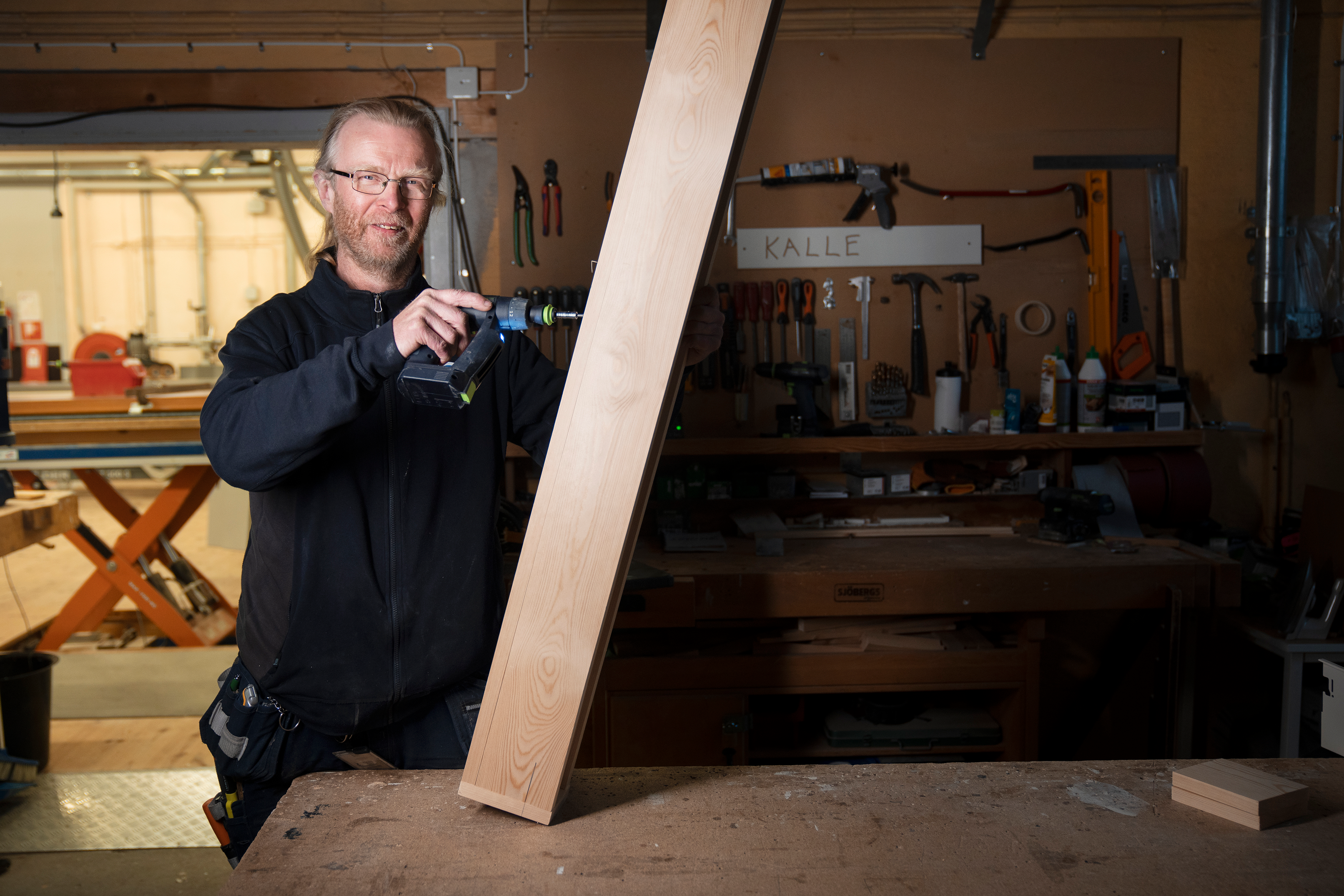 Evert Bischof, snickare, AB Kristianstadsbostäder, ABK borrar i en bräda.