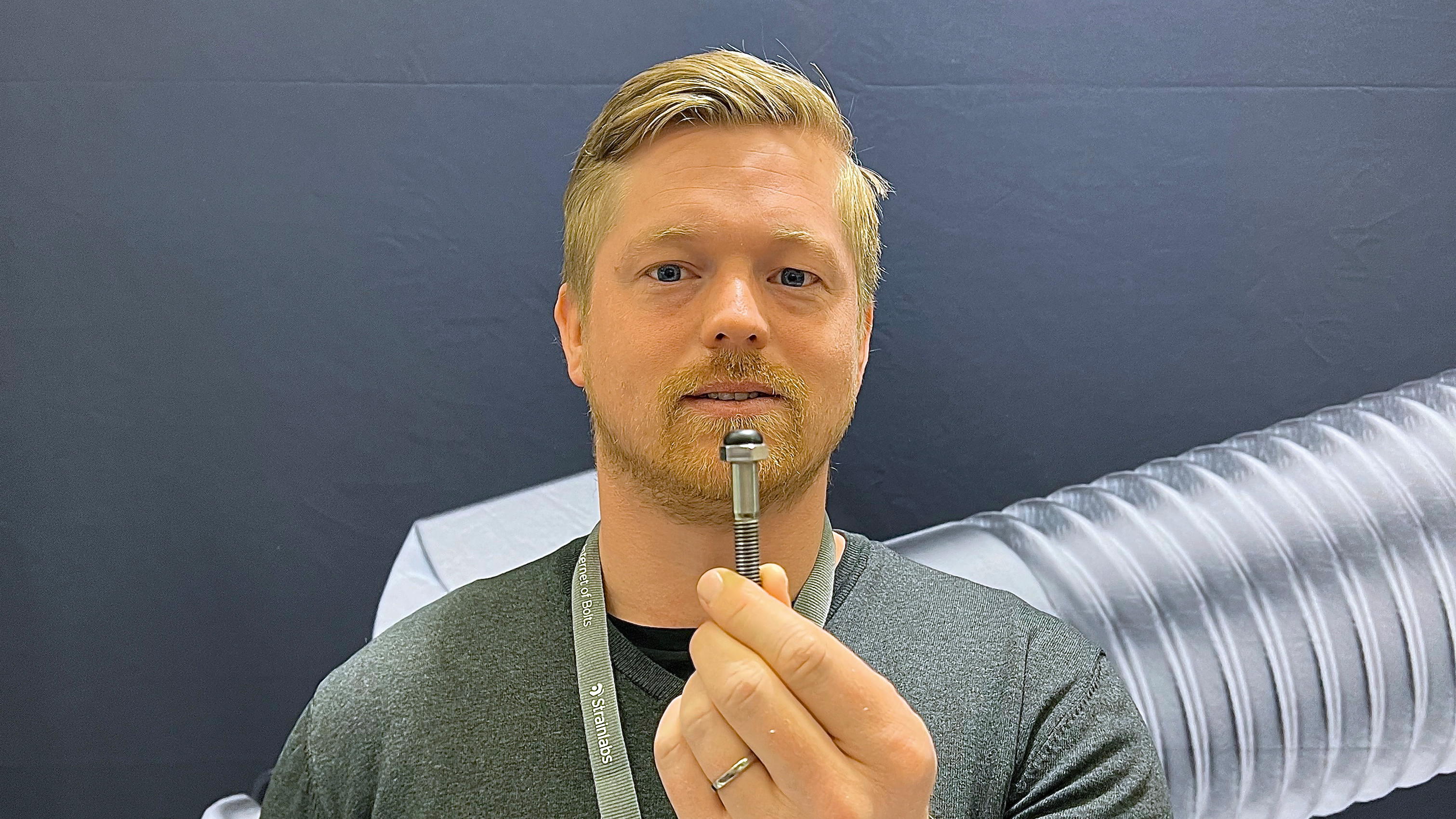 Michael Fransson håller i produkten, en skruv med svart topp.