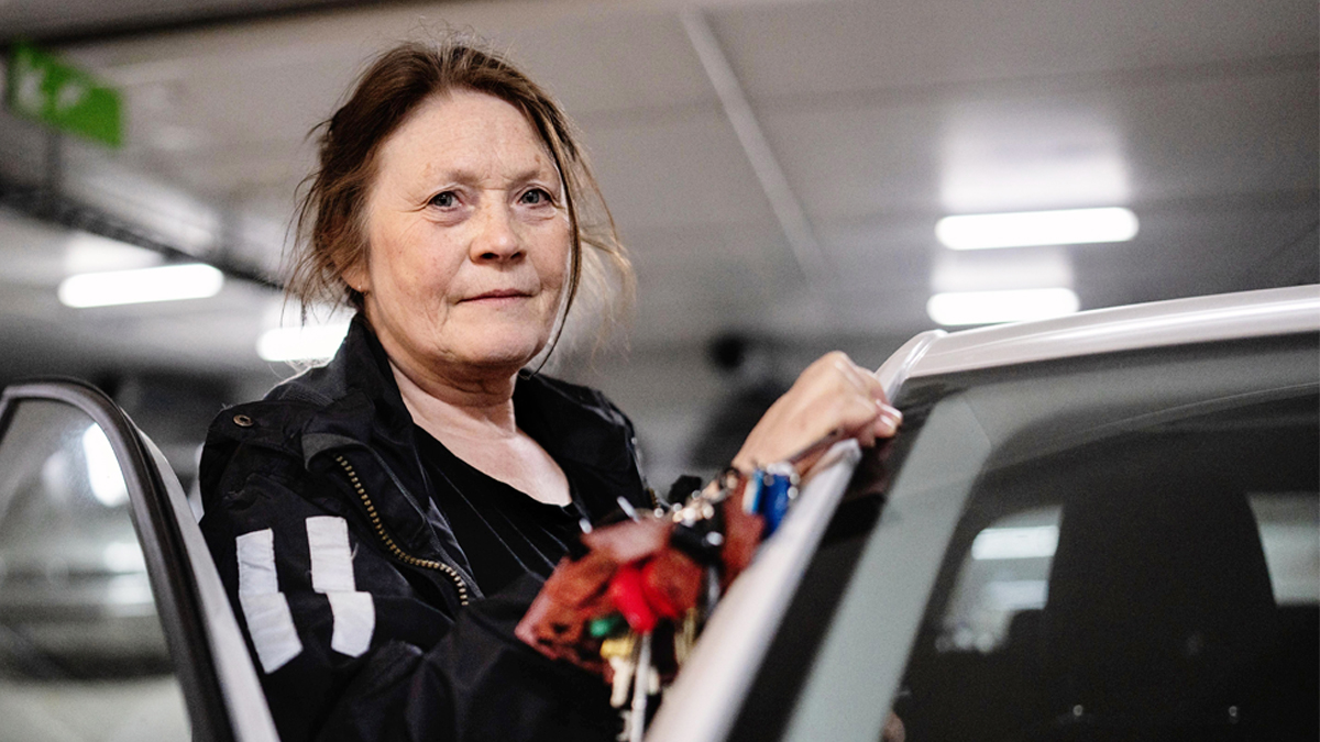 Carina Lundström på väg in i en vit bild, med en rejäl nyckelknippa i näven.