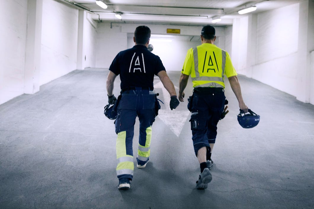 Två personer med Assemblins logga på sina arbetskläder.