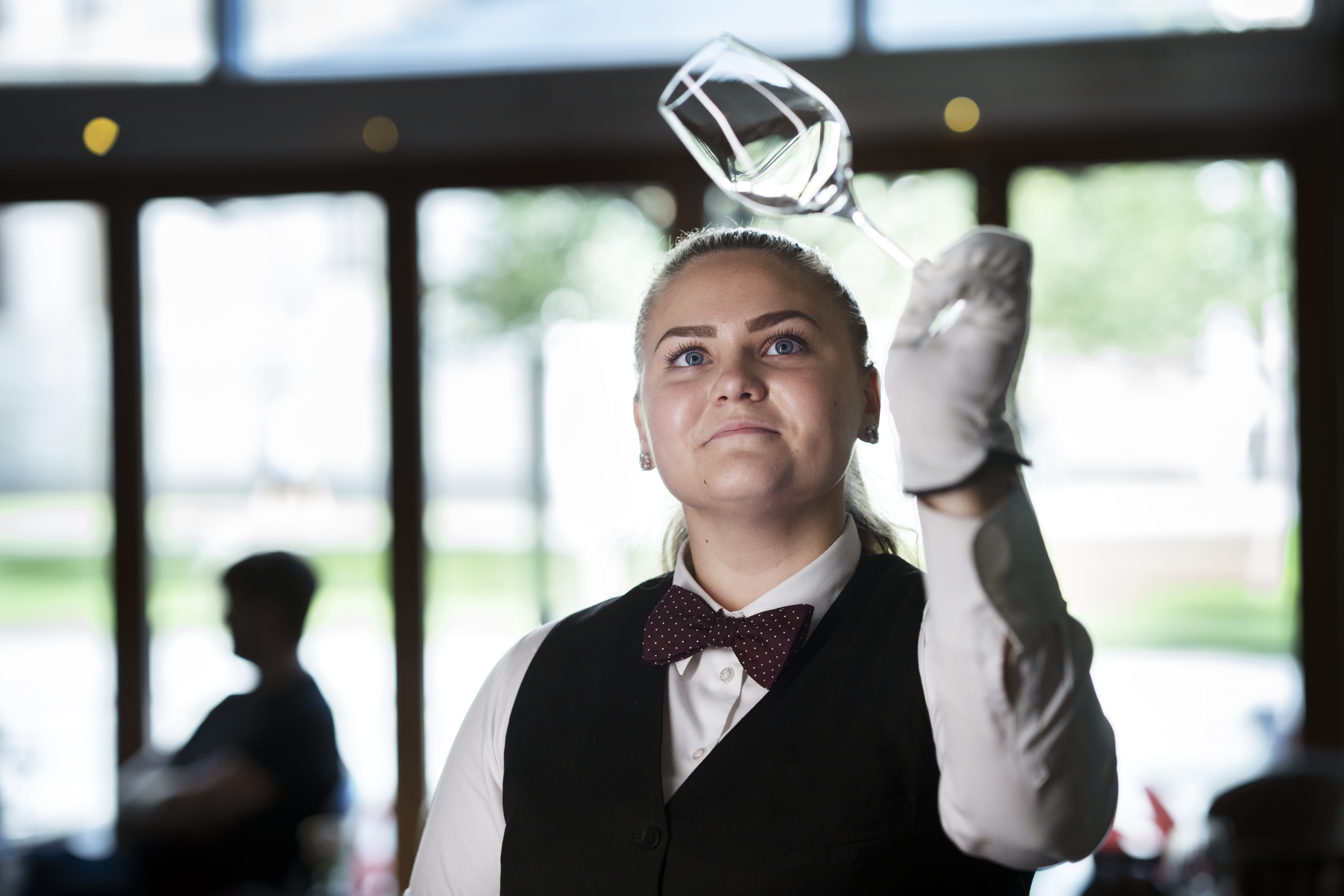 Evelina Fäldt som vunnit yrkes-em kollar att ett vinglas är rent.