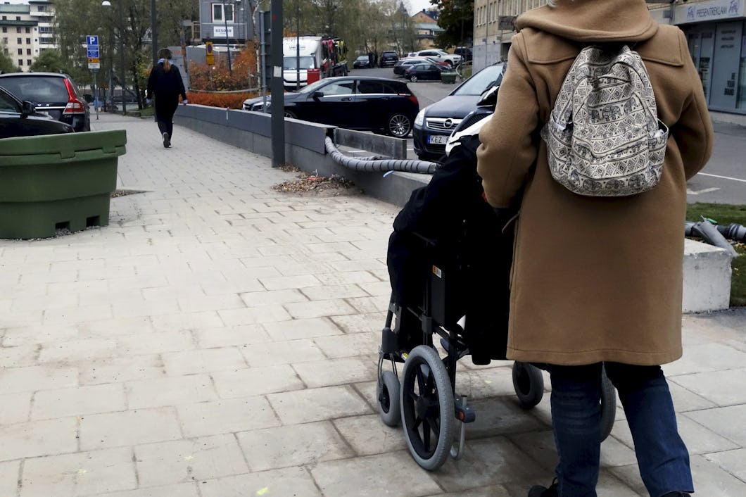 Kvinna i rullstol får hjälp av sin personliga assistent.