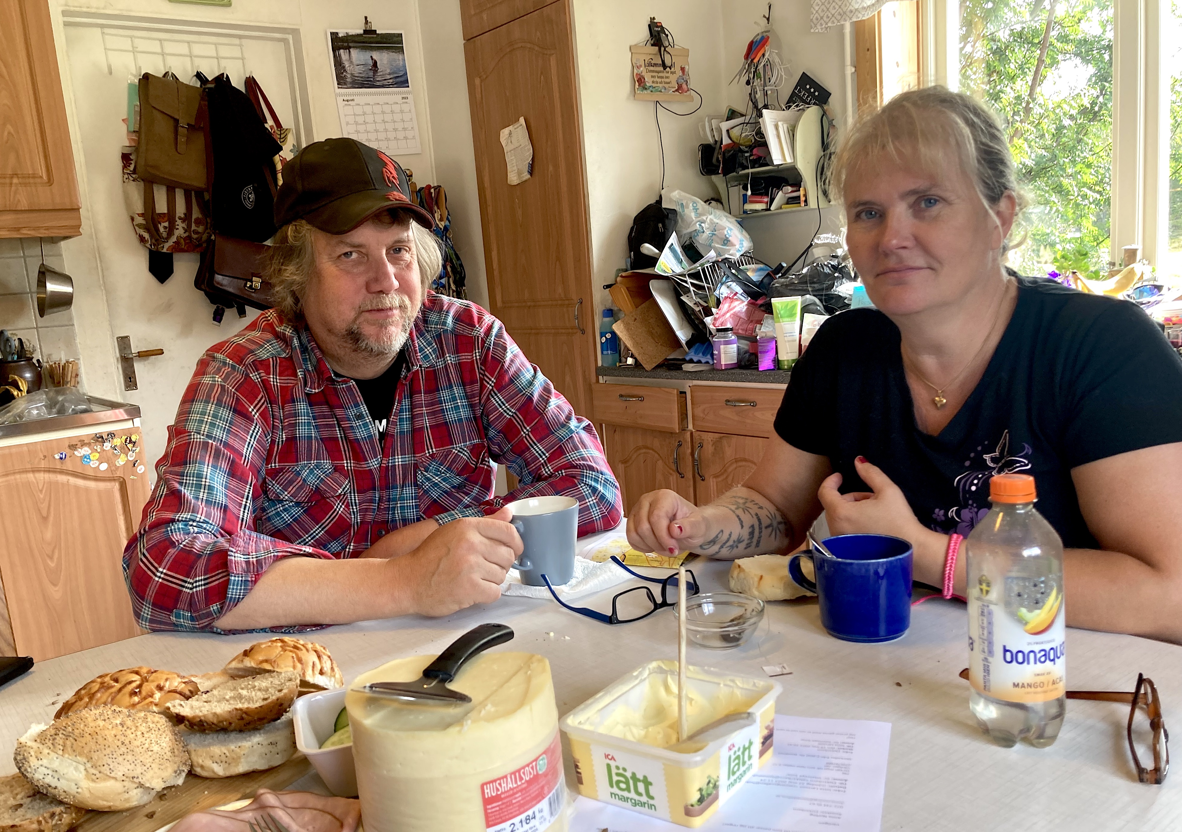 Jan och Lotta sitter i sitt kök vid köksbordet.