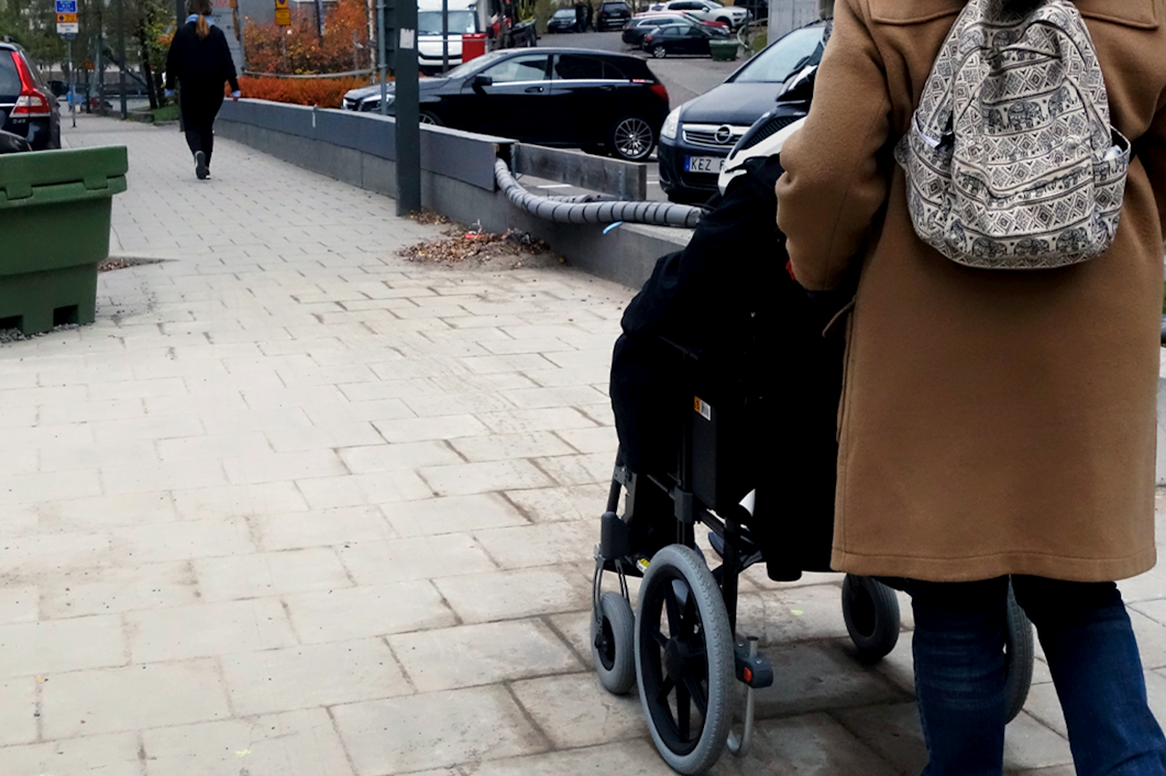 Kvinna i rullstol får hjälp av sin personliga assistent.