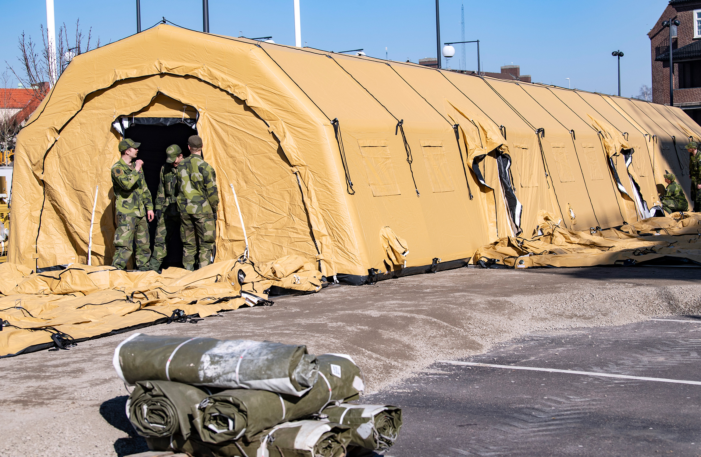 Tjänstemän från militären och Socialstyrelsen arbetar på torsdagen med att bygga en intensivvårdsmodul utanför ett sjukhus i Helsingborg.