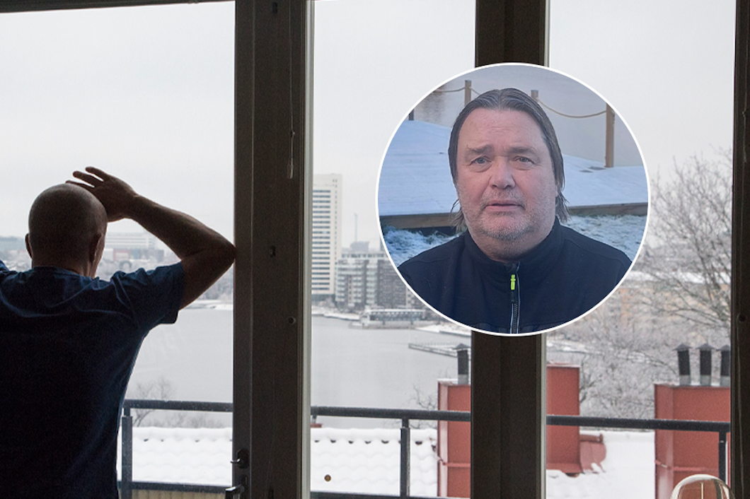 Deprimerad man står och tittar ut genom fönster.