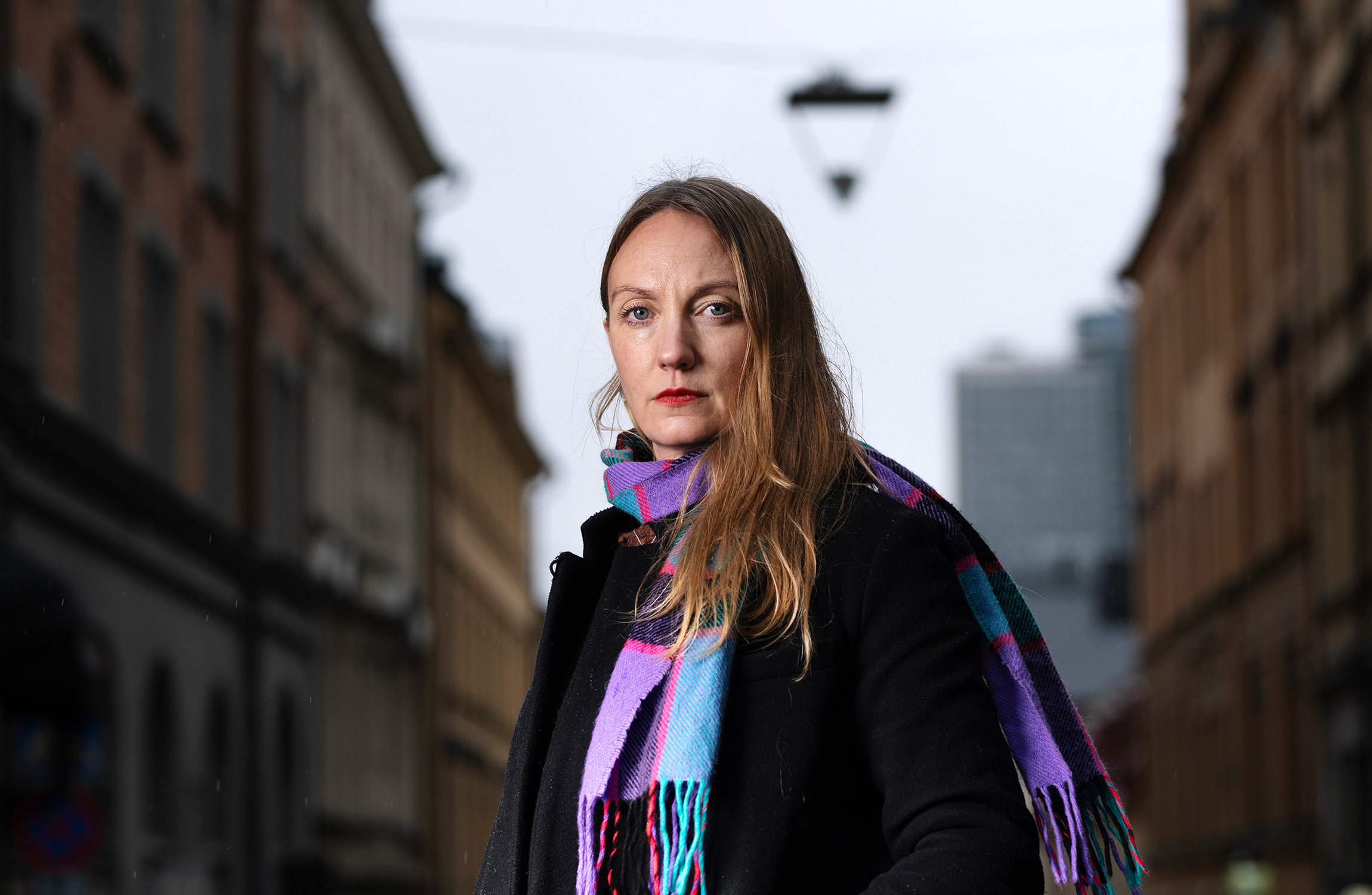 Elin Månson i en lila halsduk ståendes på en gata.