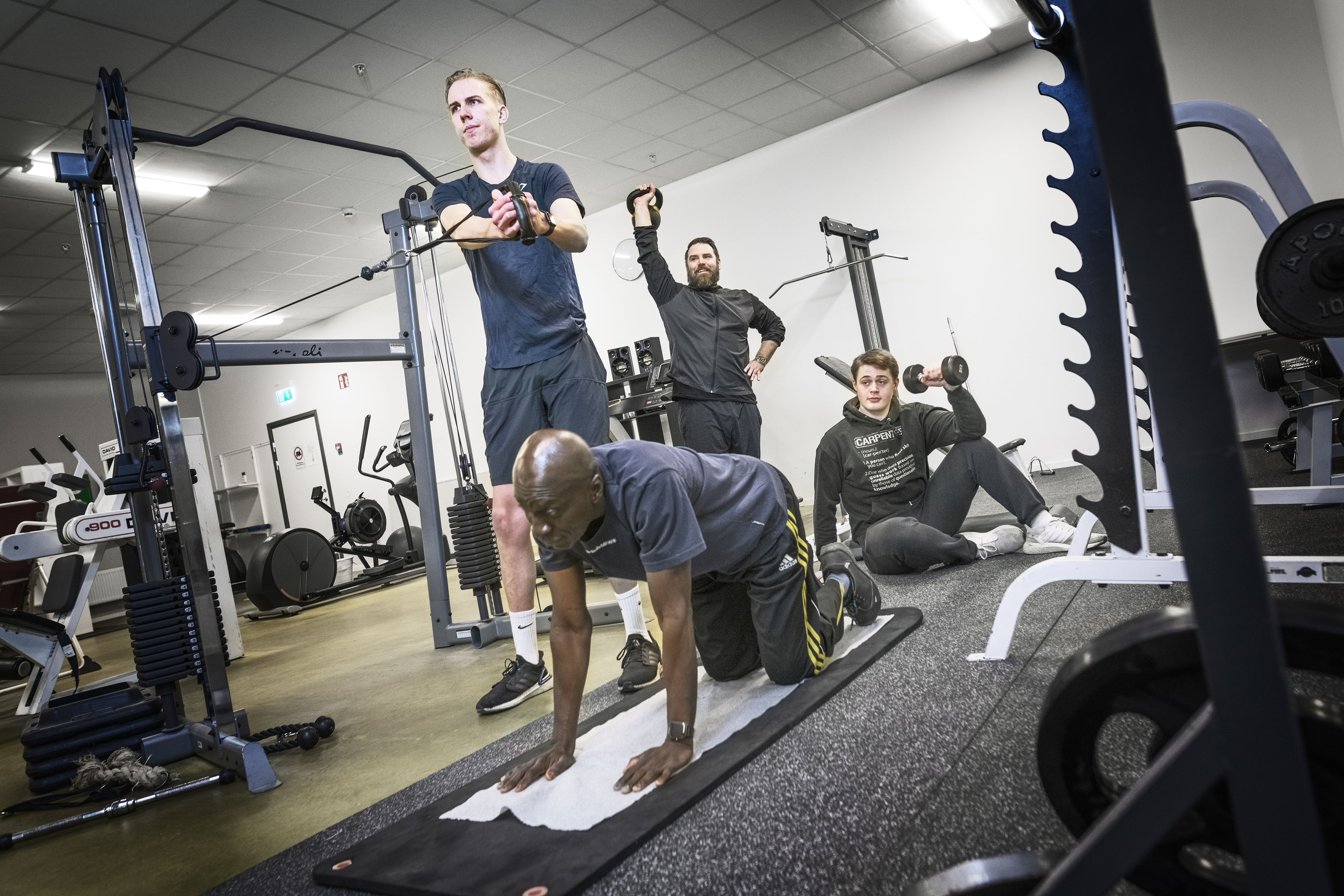 En grupp människor som tränar på ett gym.