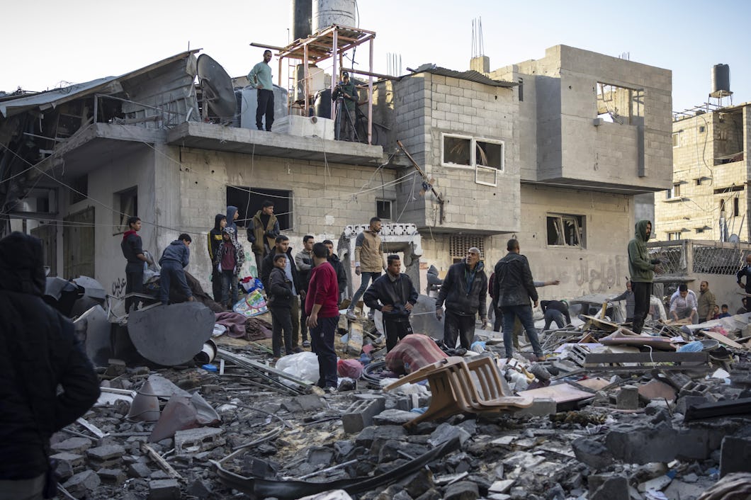 En grupp människor som står i spillrorna av ett hus i Gaza.