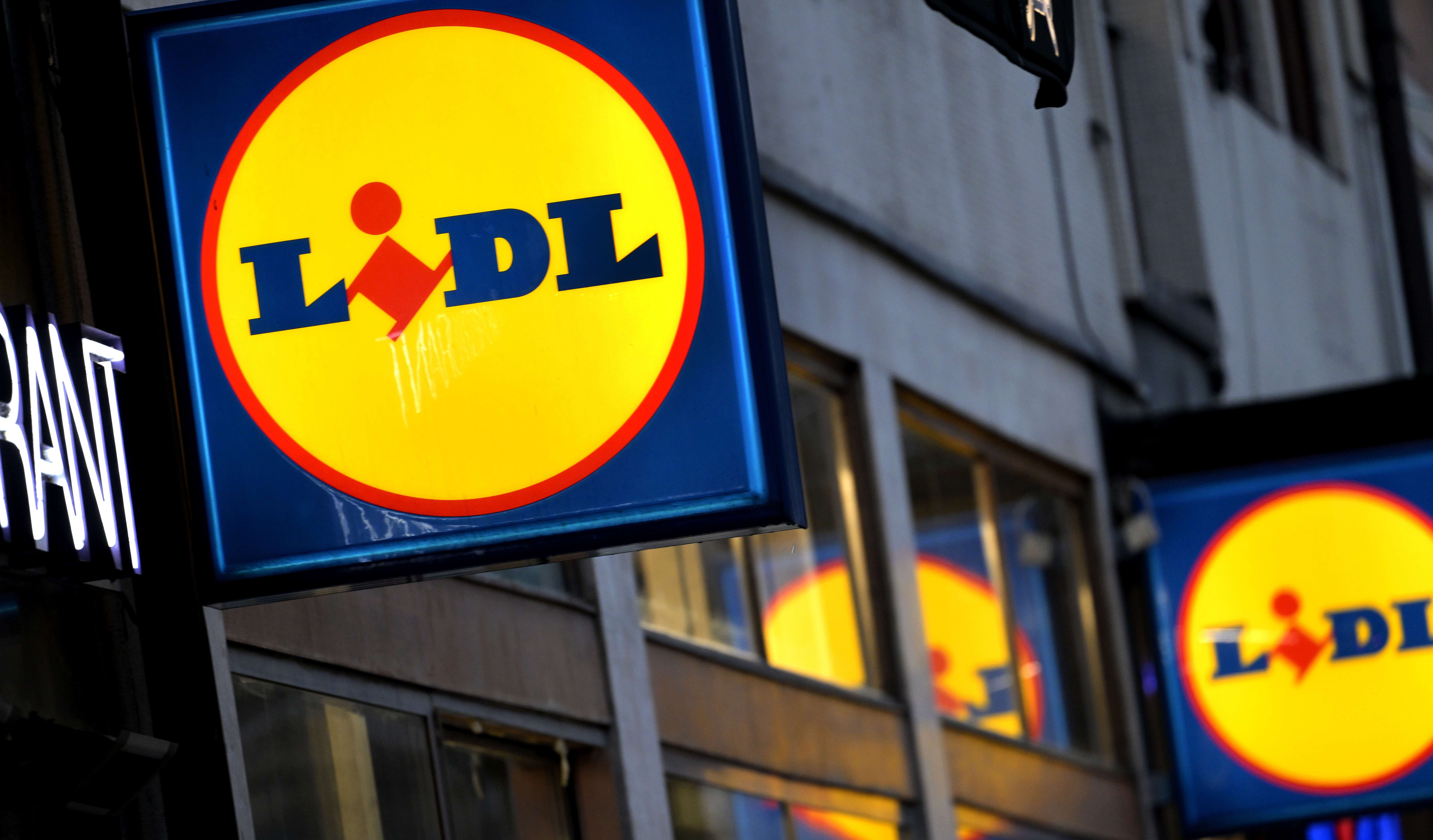 En skylt för Lidl hänger på sidan av en byggnad.