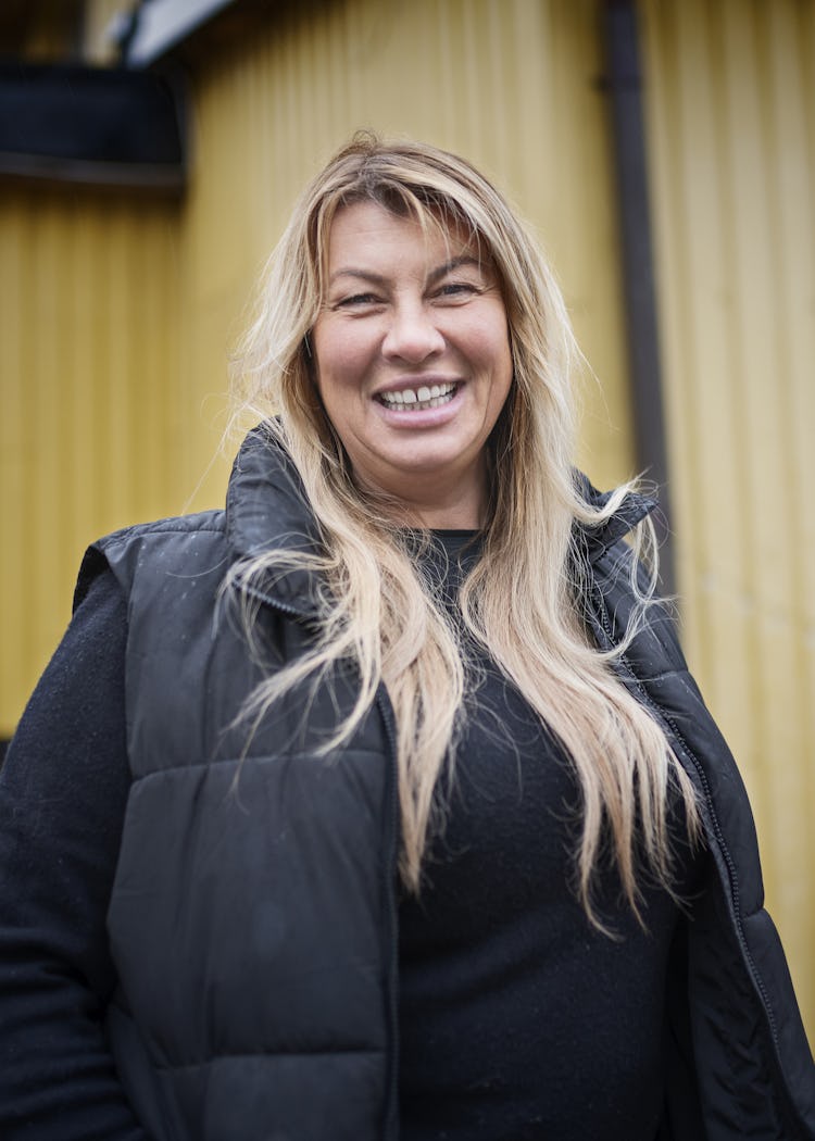 Malin Enström ler framför den gula byggnaden Ladan.