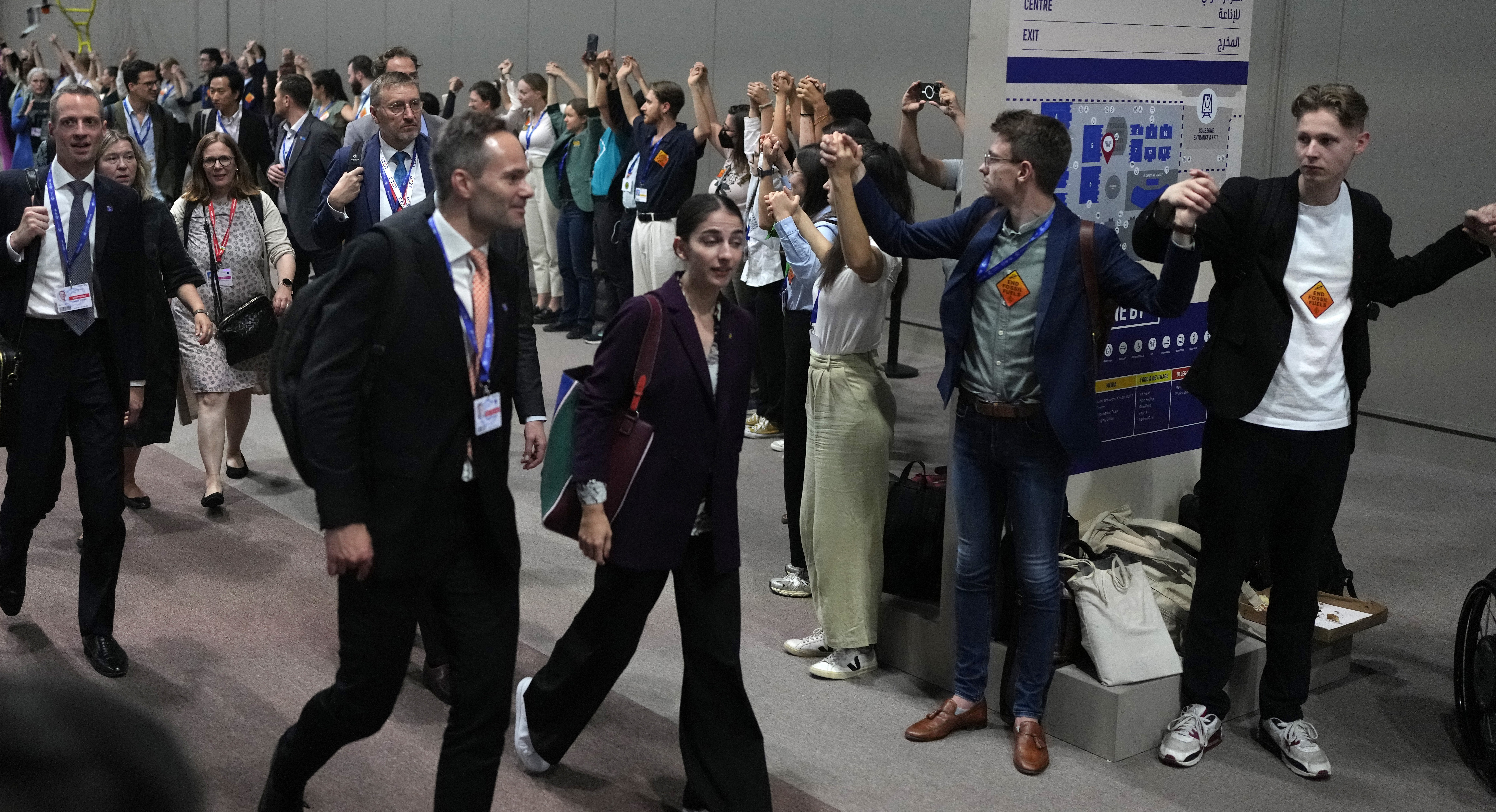 Romina Pourmokhtari går i en korridor med demonstranter.