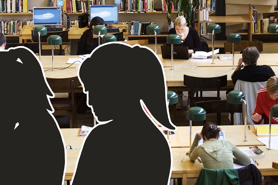 Silhuetter av människor som sitter vid skrivbord i ett bibliotek.