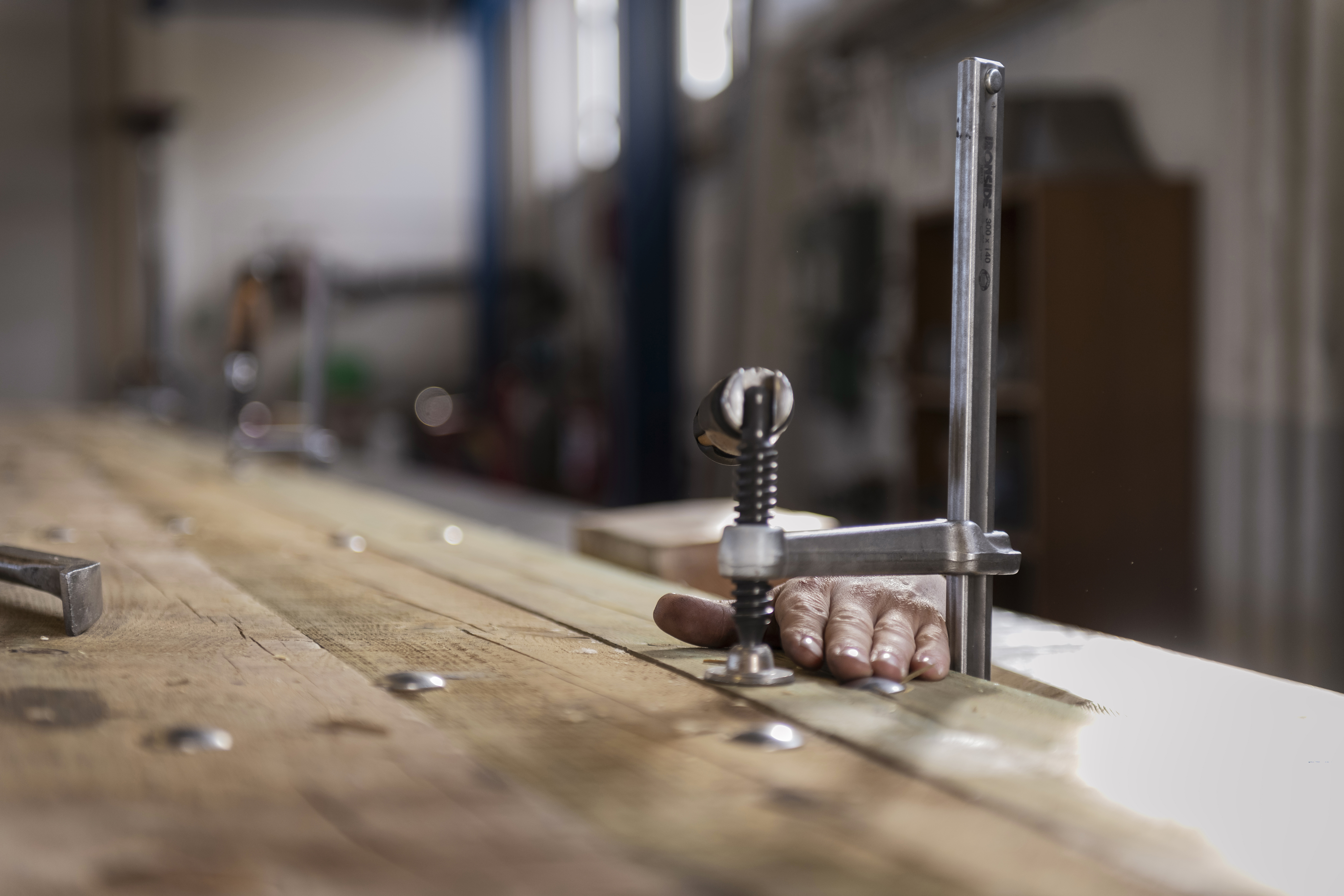 Närbild på en hand som sticker upp bakom en tving.