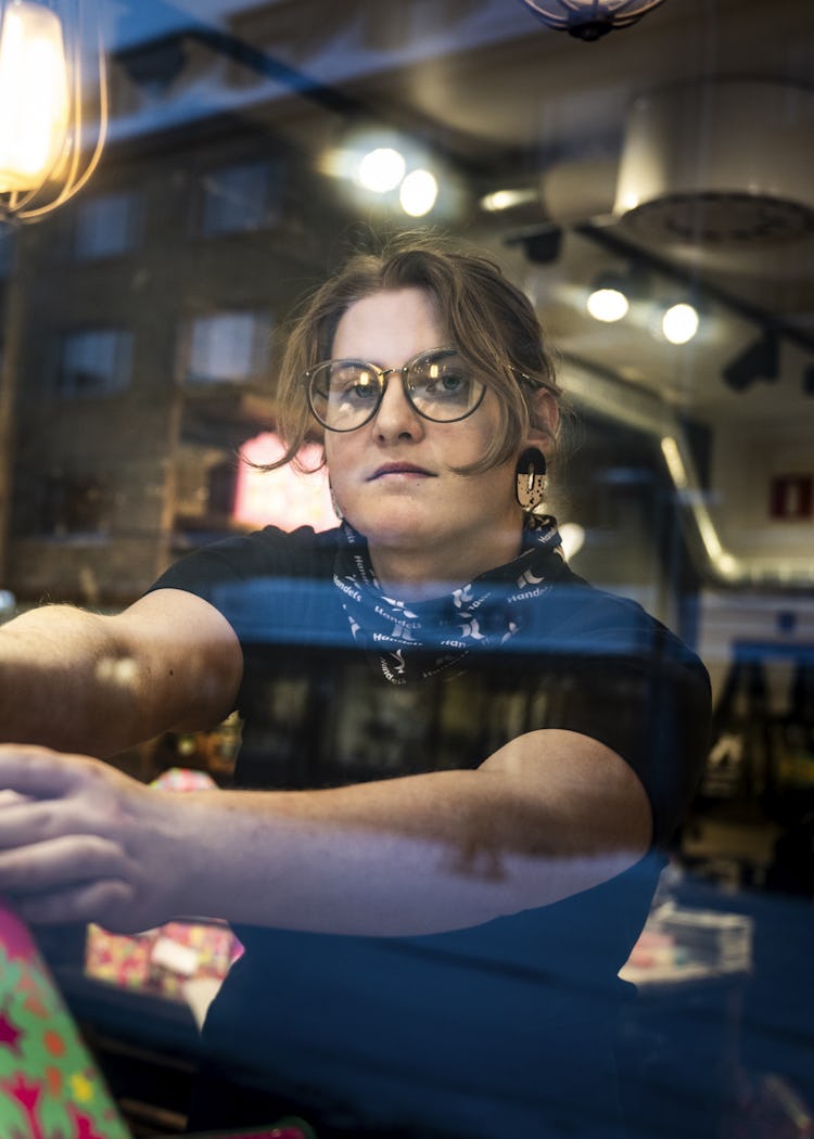 En person håller en presentpåse i ett skyltfönster.