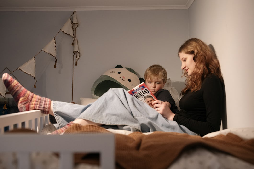 Cecilia Ahnberg och Albert Aaröe sitter i en säng och läser en bok.