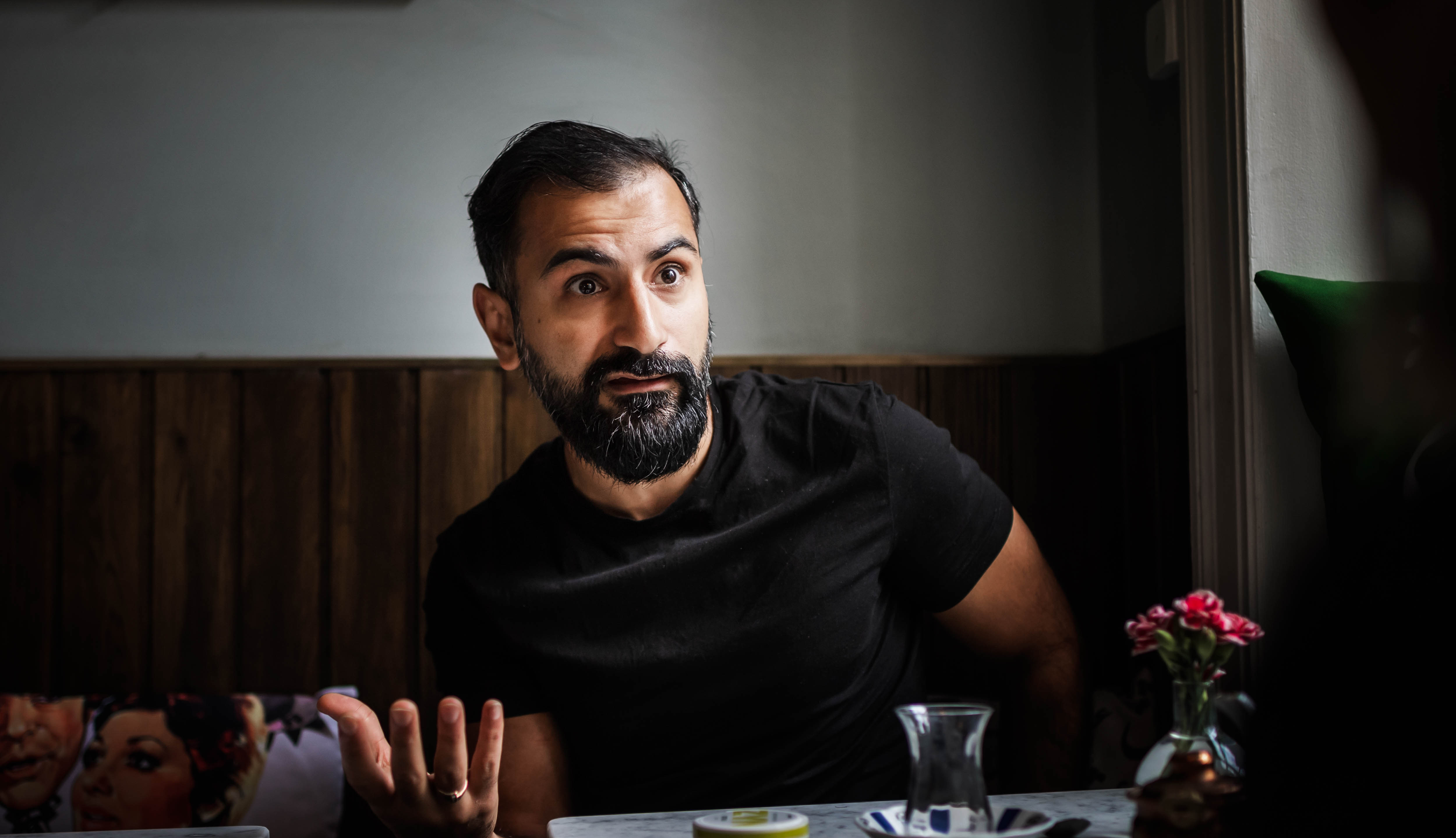 Person sitter bredvid ett bord.