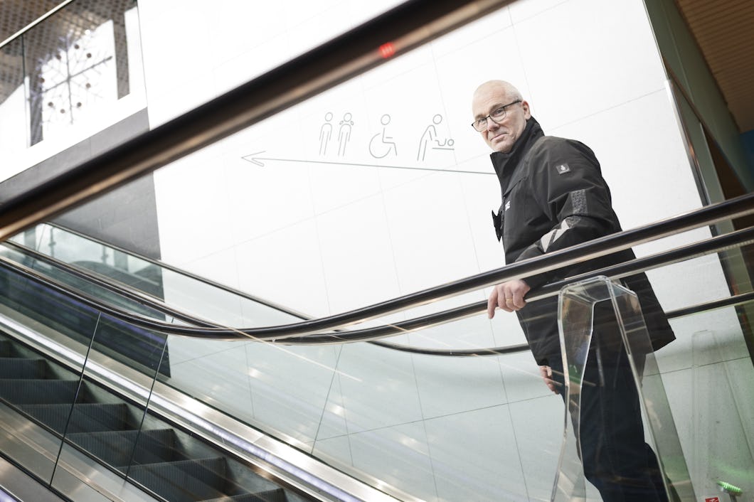 Hans Göthberg som står på en rulltrappa i ett köpcentrum.