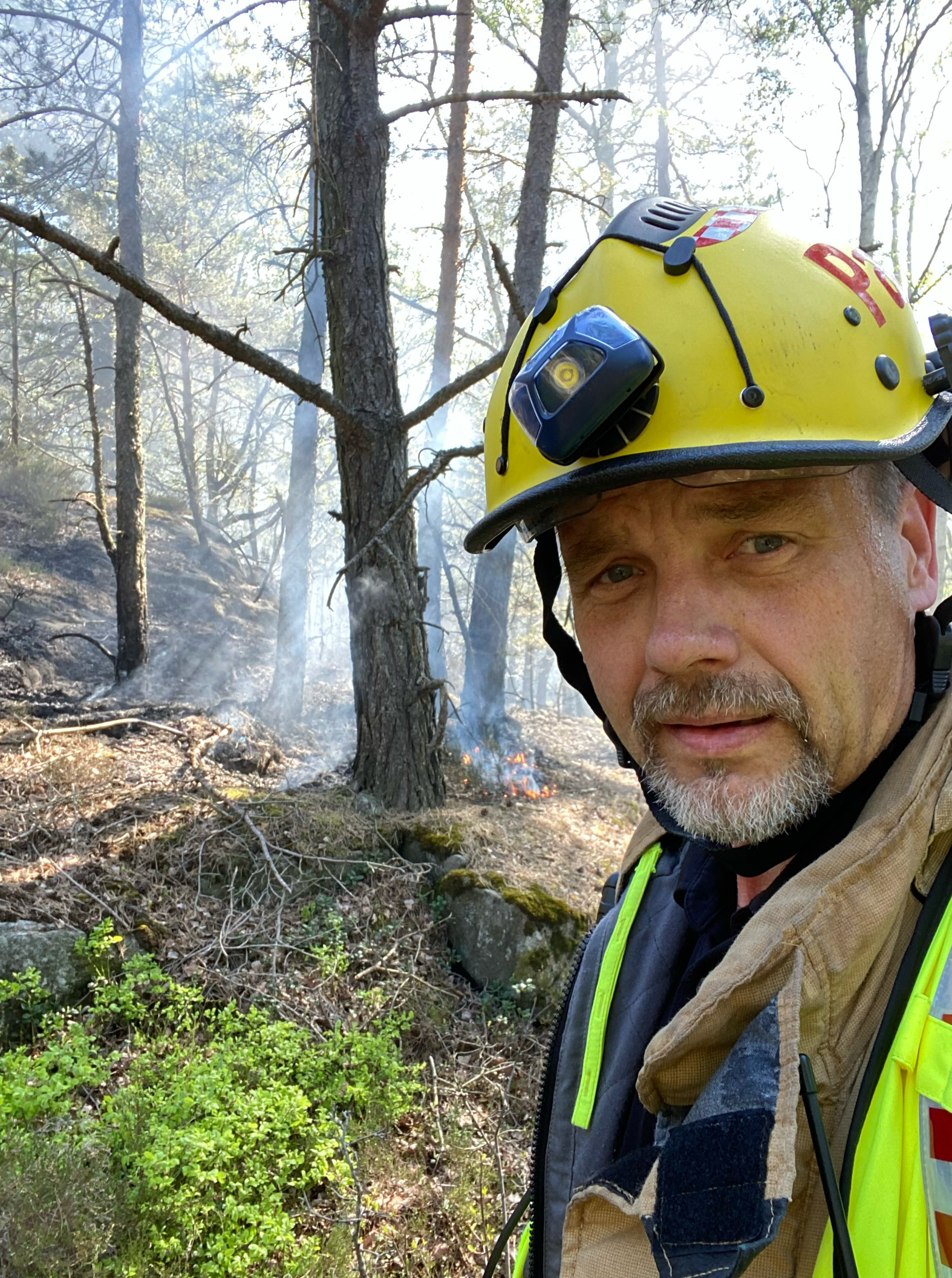 Per Albin Halldin som bär en gul hjälm i en skog.