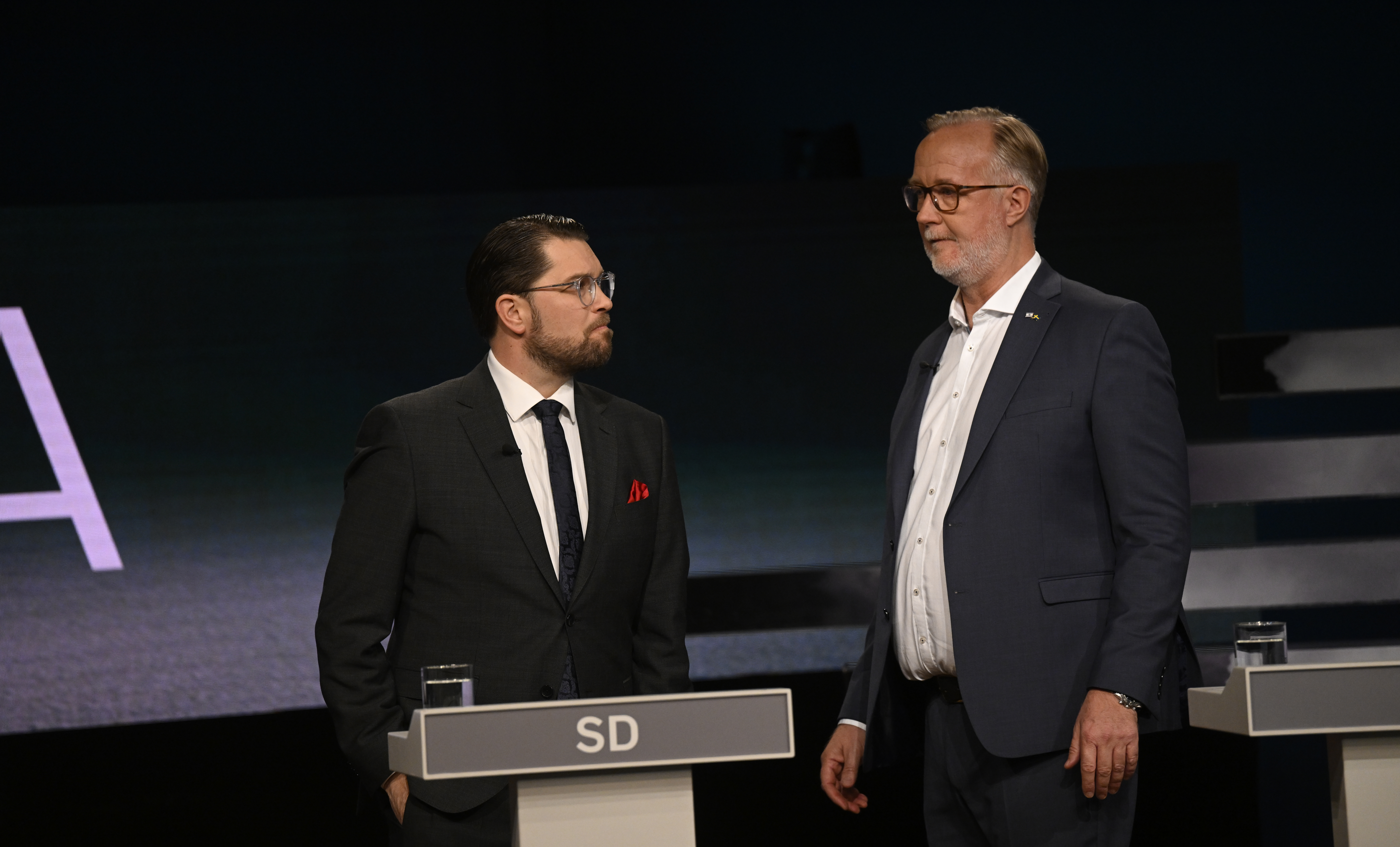 Två män som står bredvid varandra framför en scen.