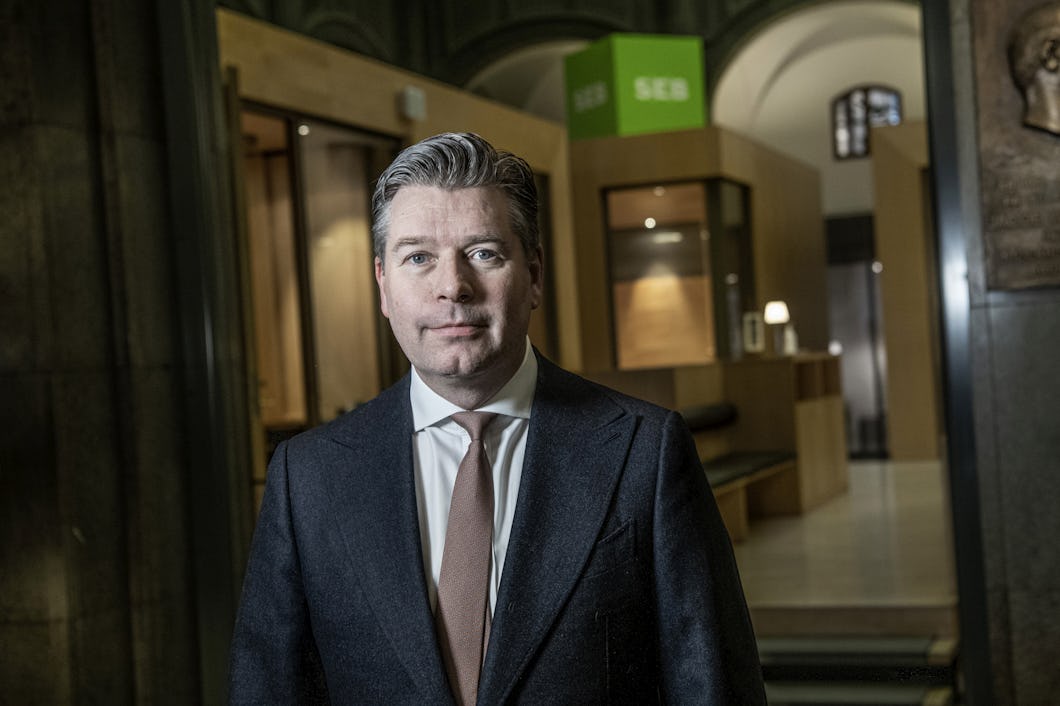 En man i kostym och slips som står i en hall.