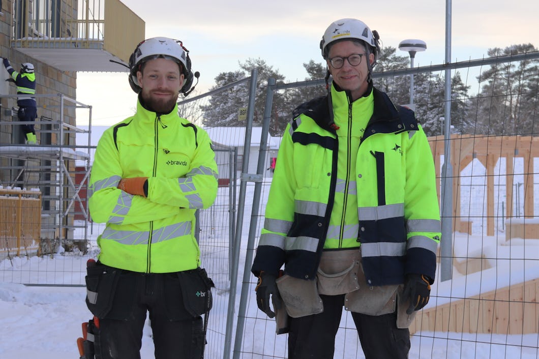 Michael och Marcus på Bravida som står framför ett staket.