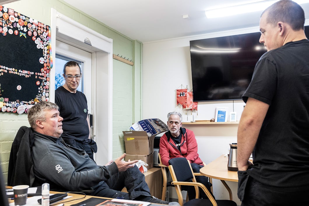 En grupp människor som sitter runt ett bord på ett kontor.