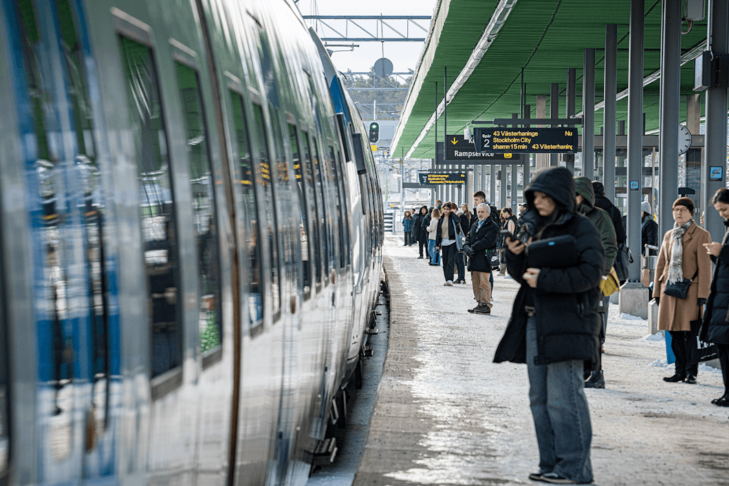 Passagerare väntar på pendeltåg på Kallhälls station.