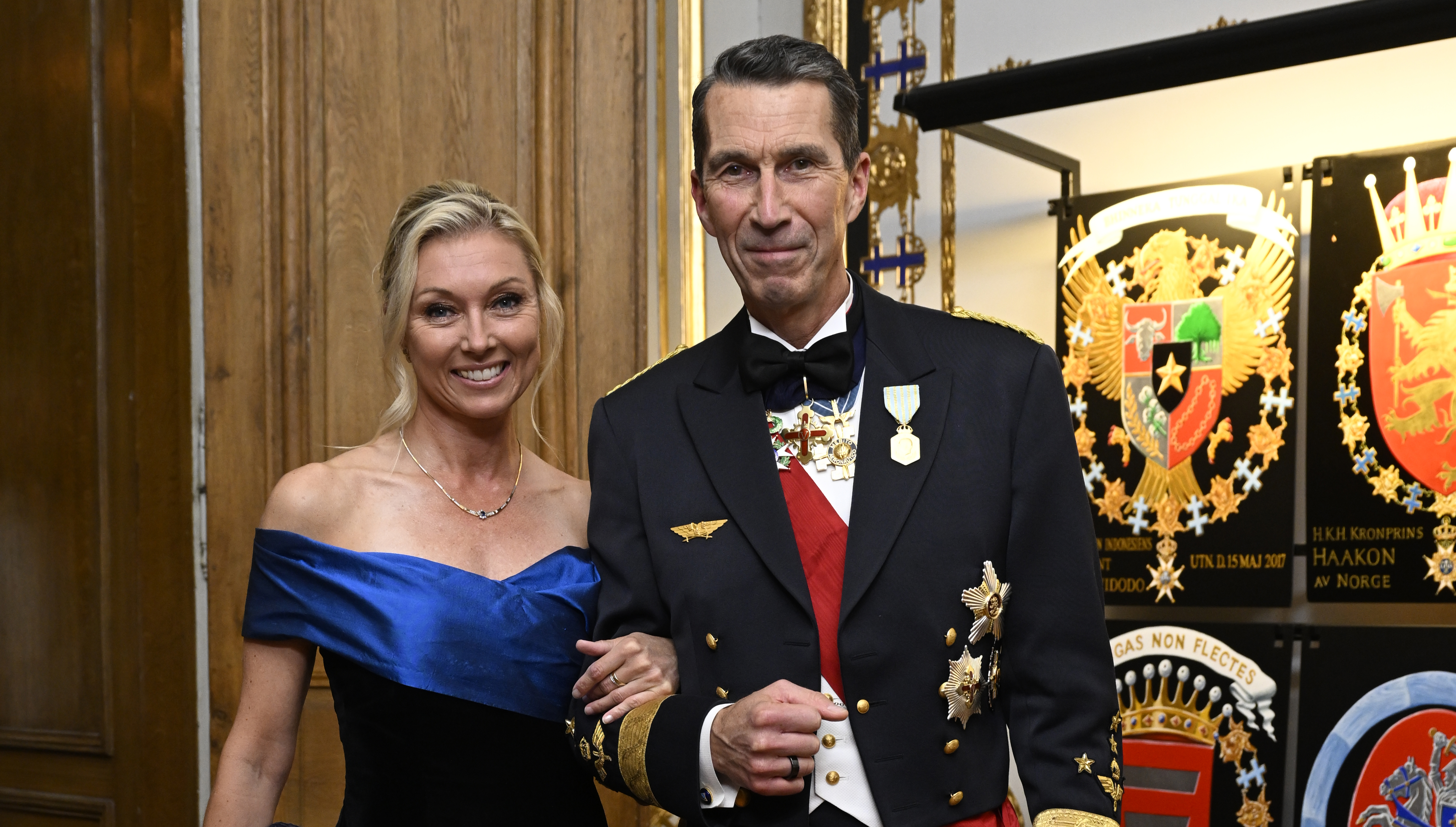 En man och kvinna i högtidlig klädsel poserar för ett foto.