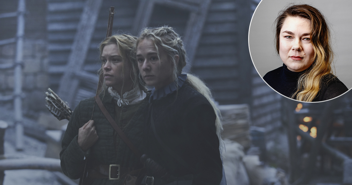 En kvinna står bredvid en kvinna med pil och båge.