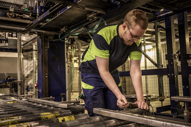 En man som arbetar på en maskin i en fabrik.