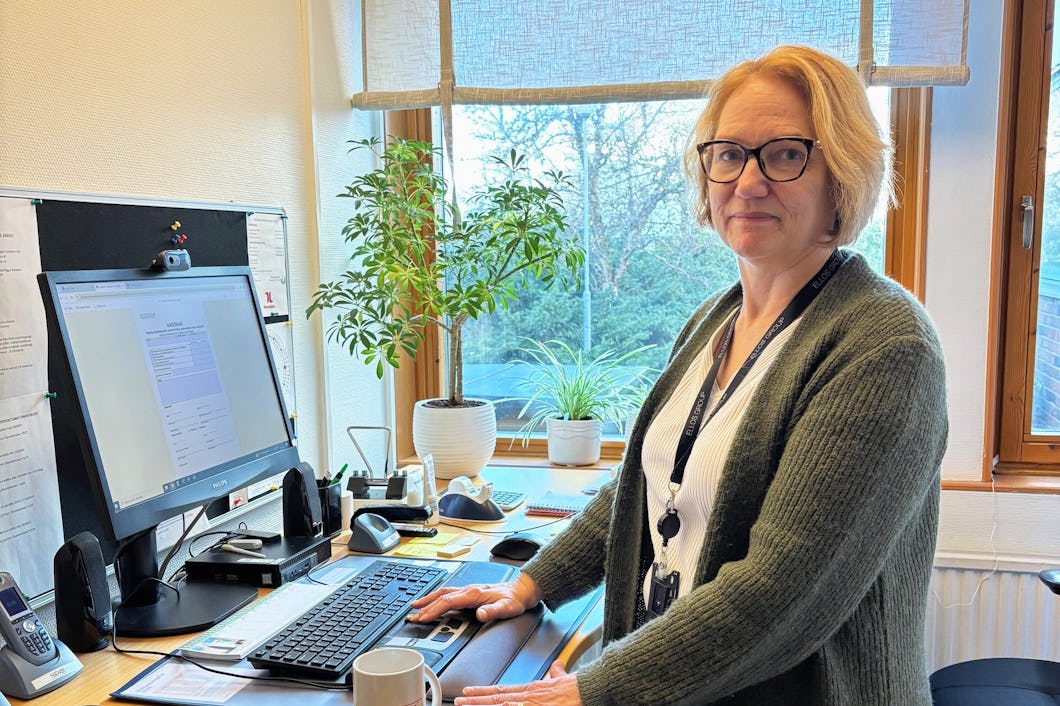 En kvinna som står framför en dator.