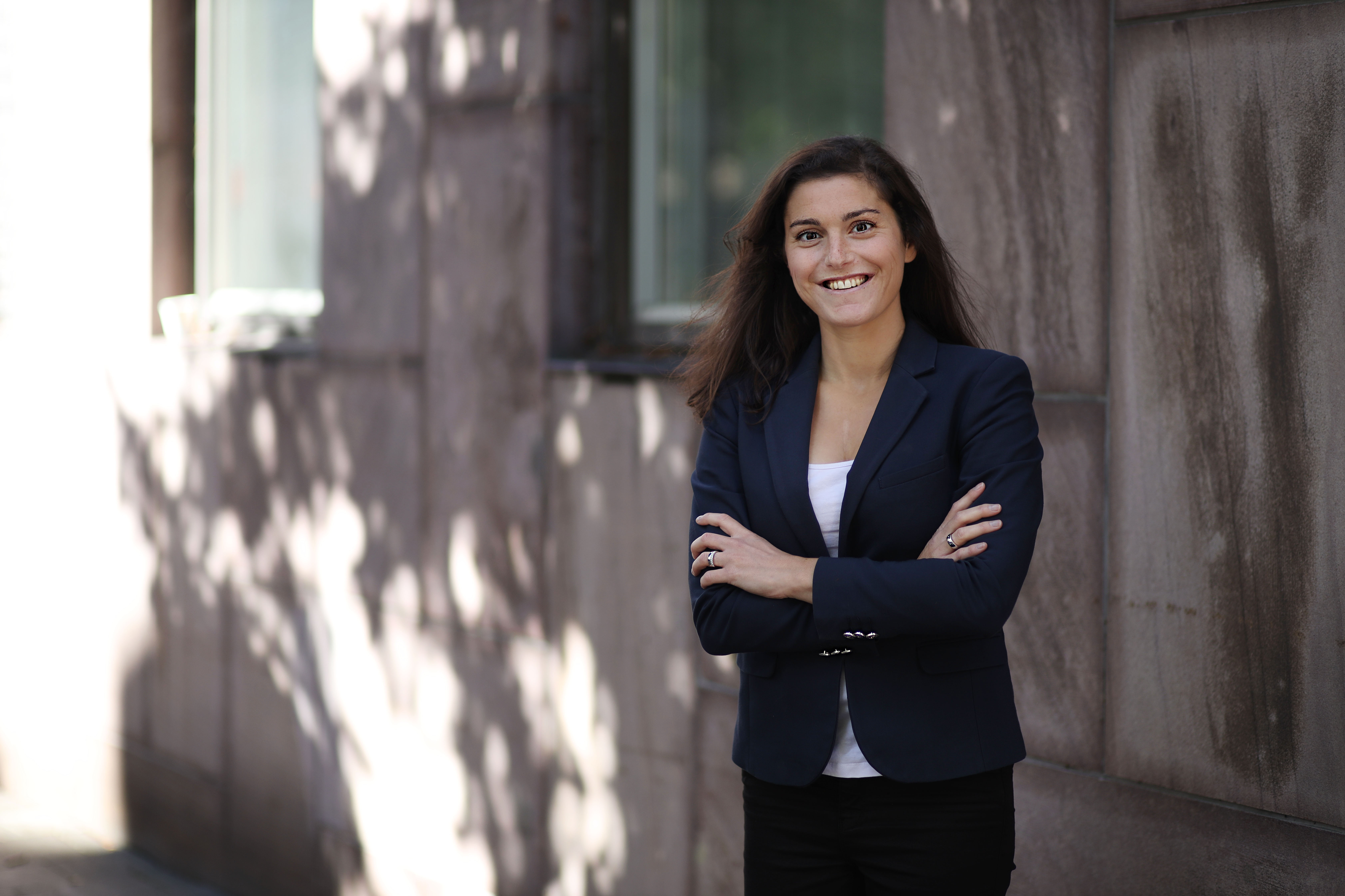 Porträtt på Jessica Forss Katz som står ute vid en husfasad.