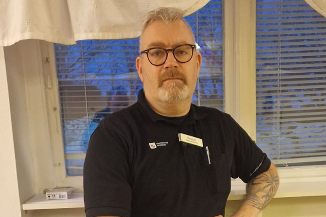 Krister Wessman, en man med tatueringar som står framför ett fönster.