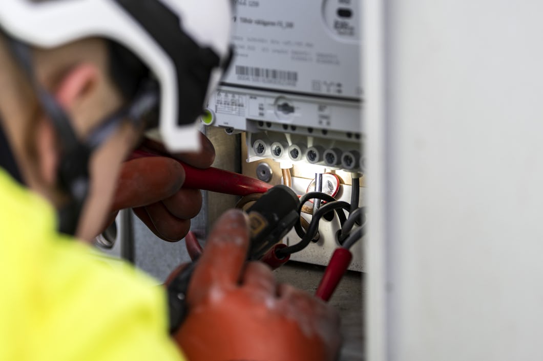 En elektriker arbetar på en elektrisk panel.