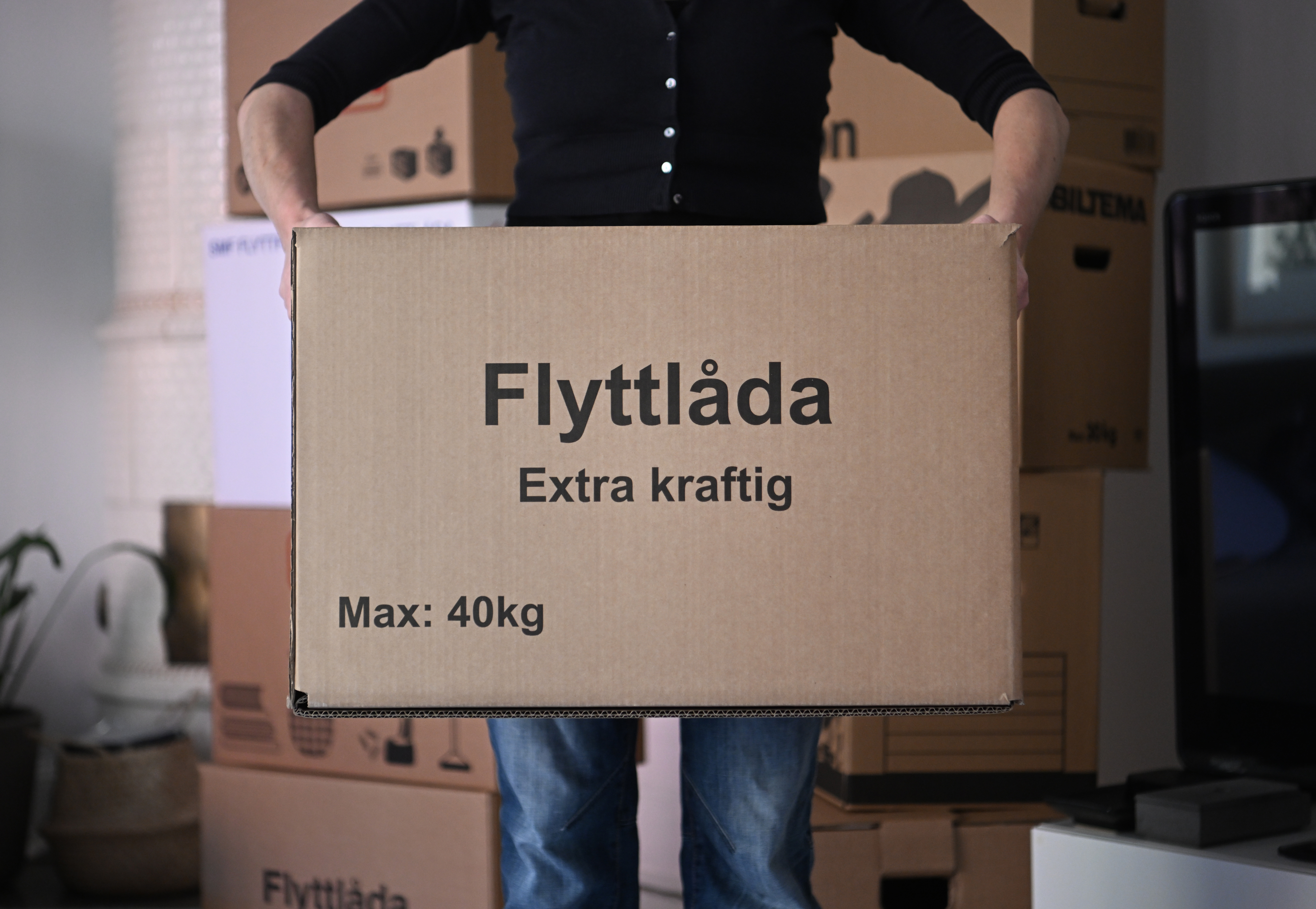 Person som håller i en flyttlåda.