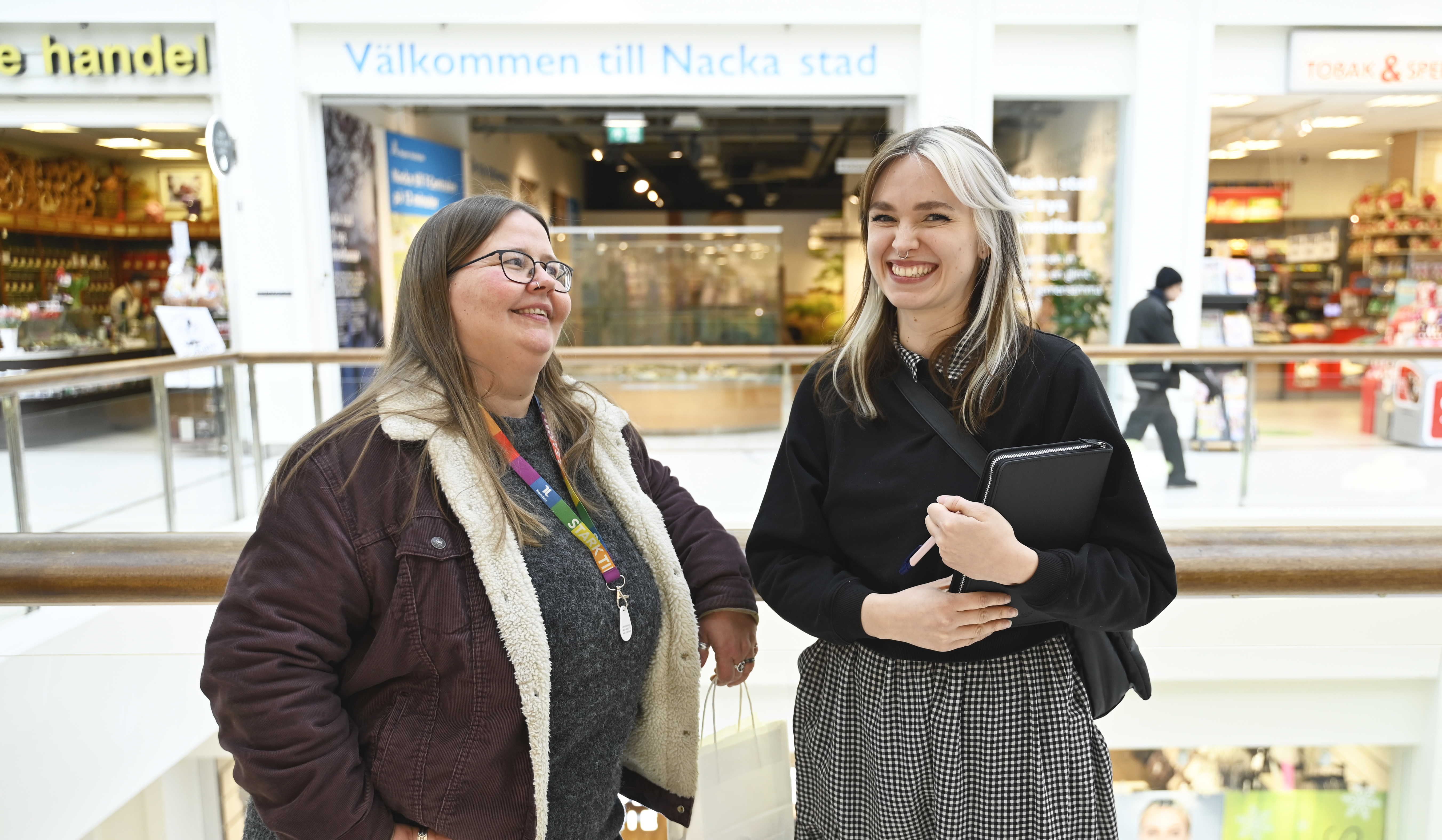 Två kvinnor står i ett köpcentrum.