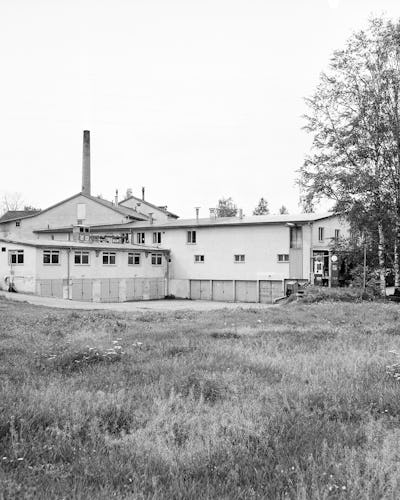 Ett svartvitt foto av en Kopparbergs Bryggeri på ett fält.