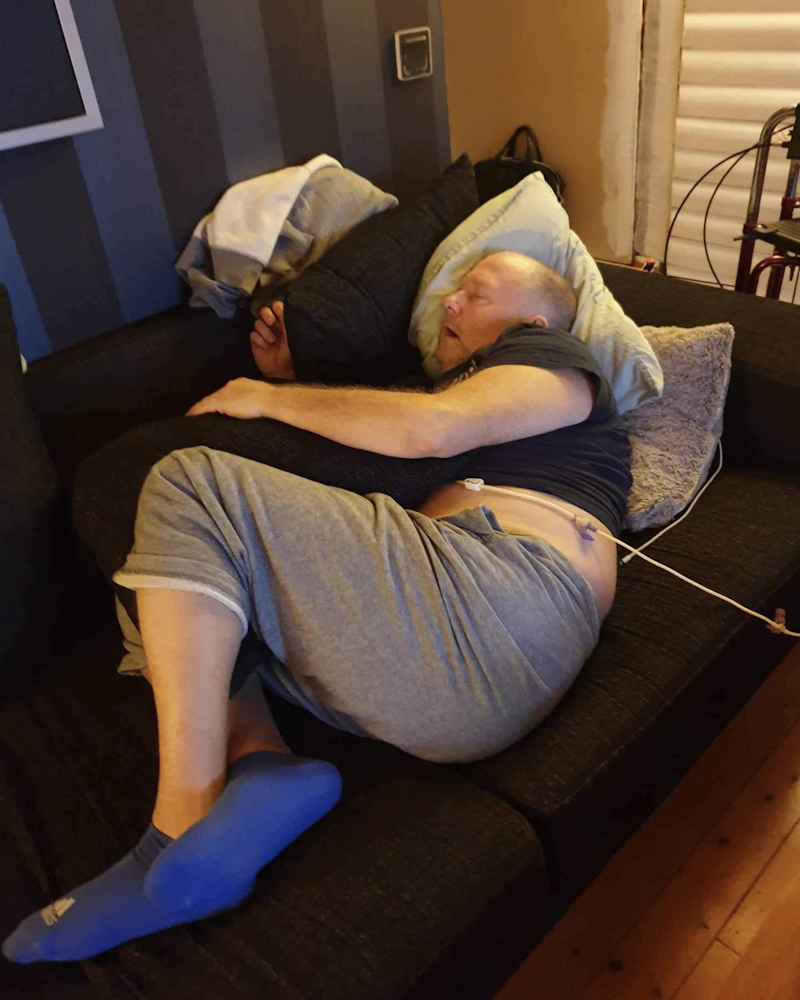 En man som sover på en soffa.