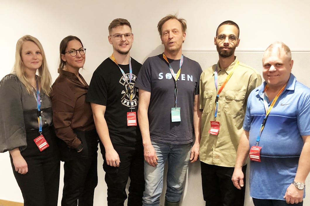 En grupp människor som står framför en vägg.