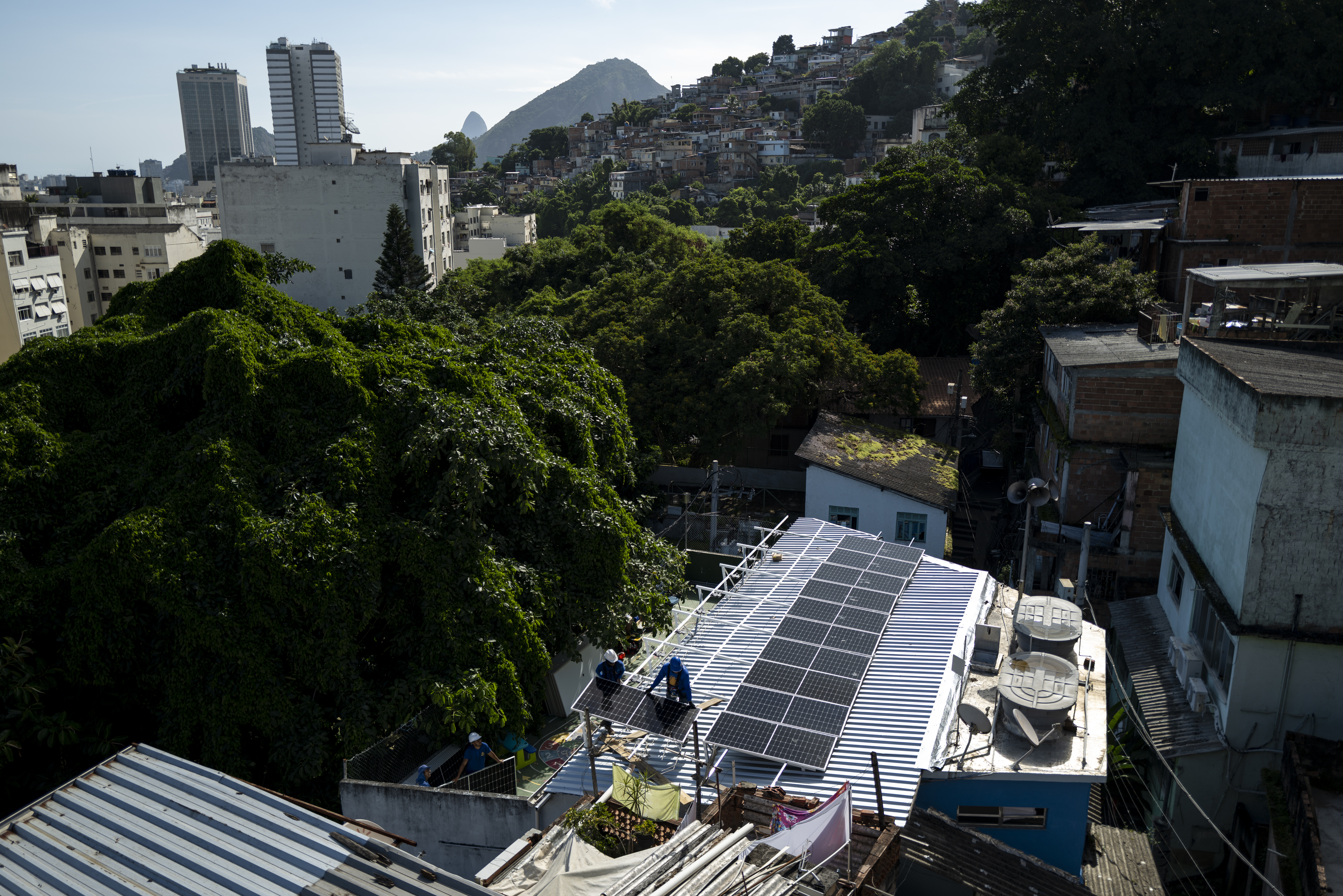 Installation av solpaneler på ett tak i en tätort.