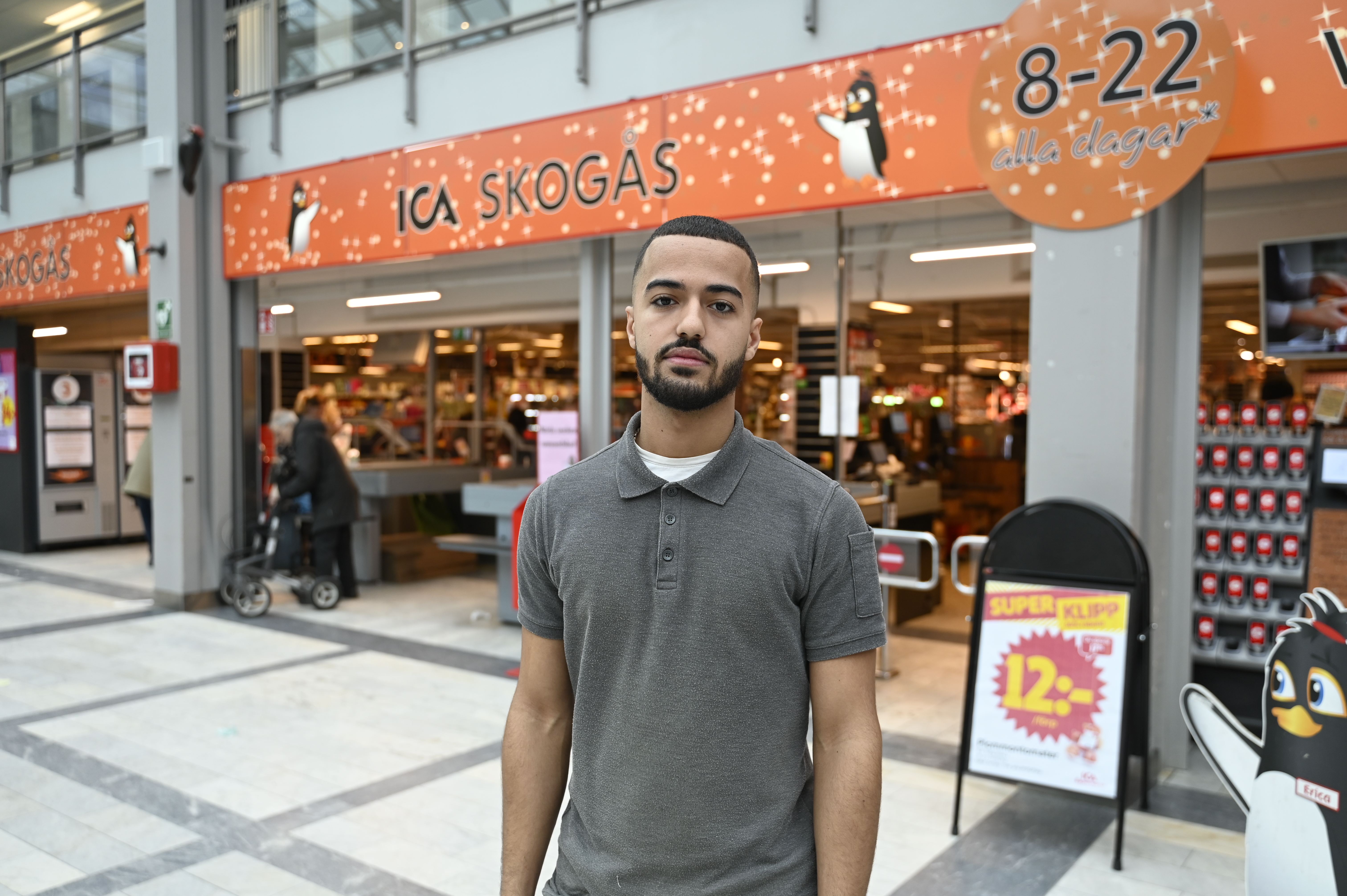 Man står framför en mataffärsingång.