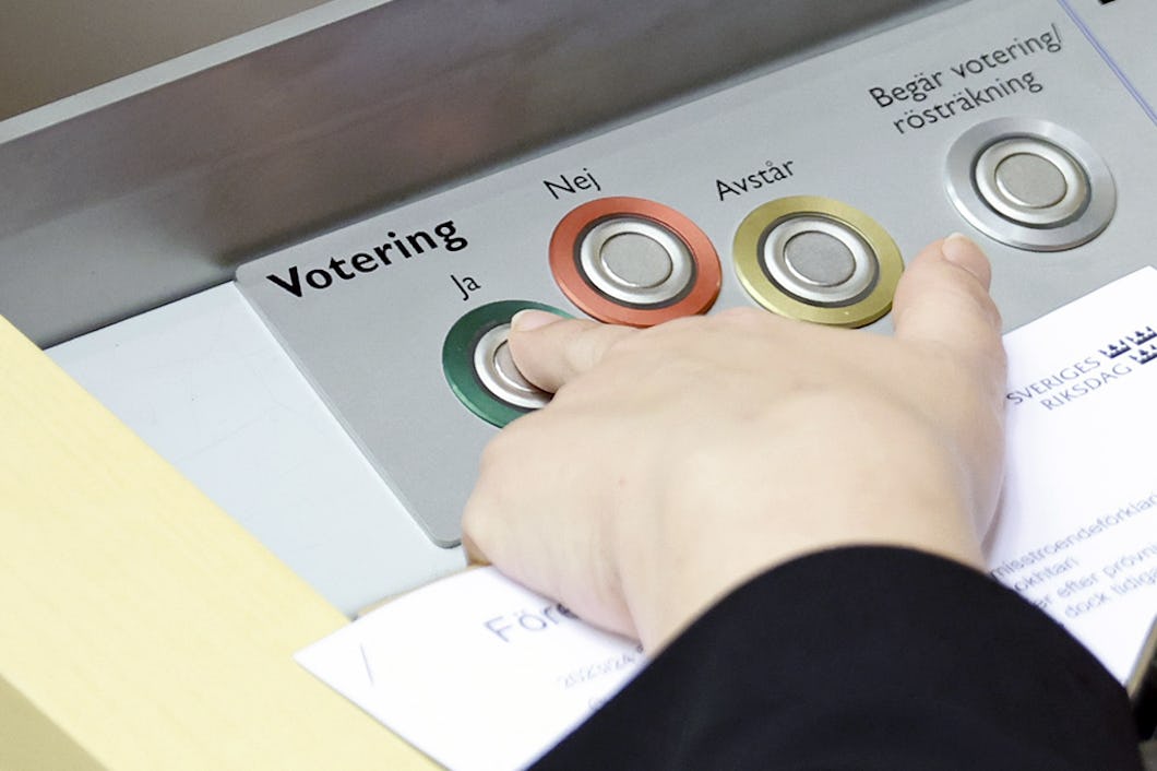 En person som trycker på knappar på en maskin i riksdagen.