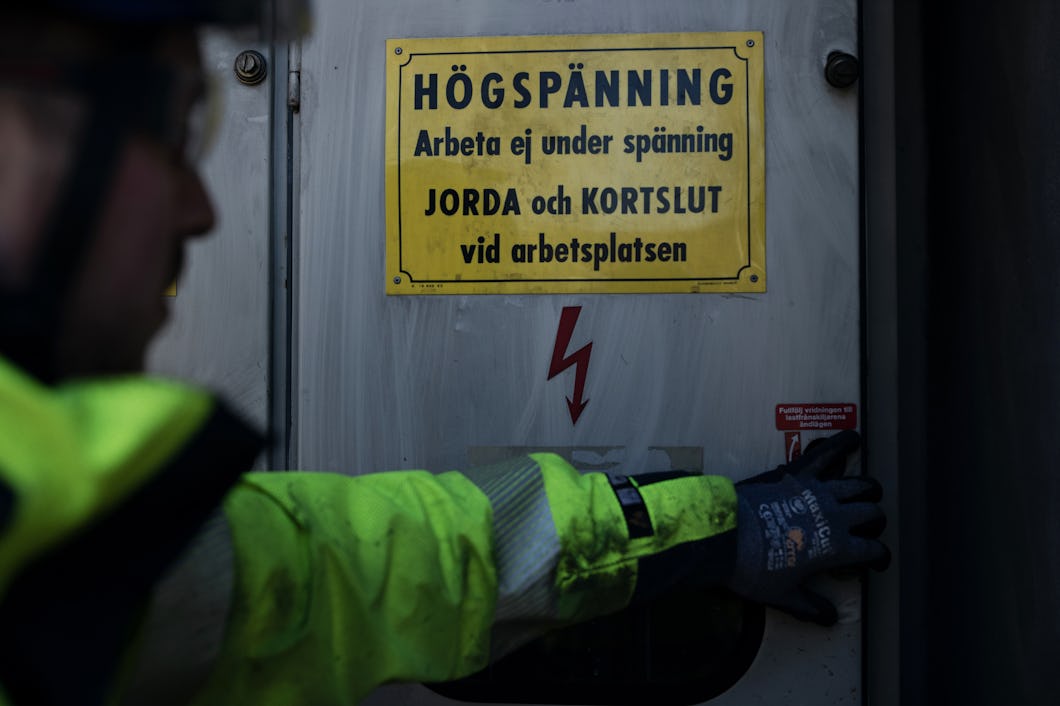 Skylt där det står ”Högspänning”.
