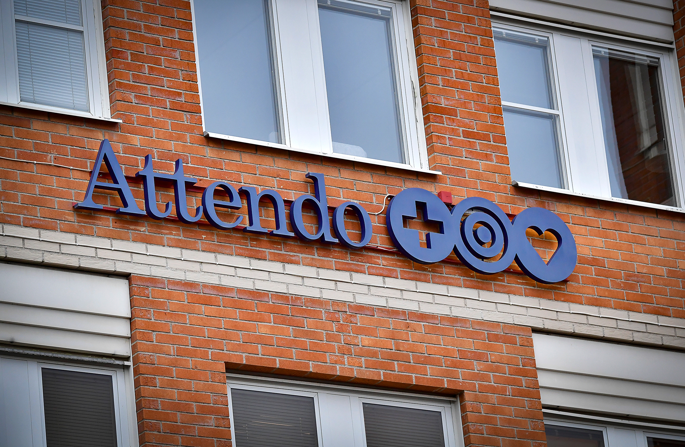 Attendos logga på tegelvägg.