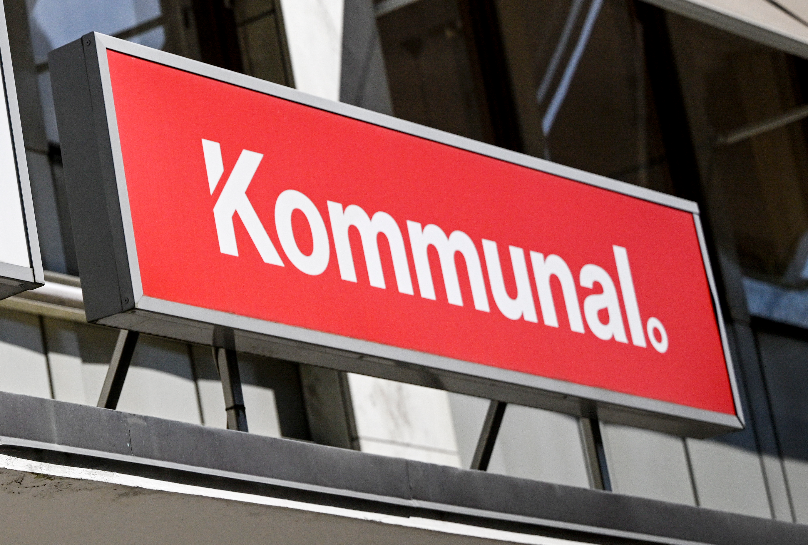 Kommunal" skrivet på en röd och vit skylt fäst på utsidan av en byggnad.